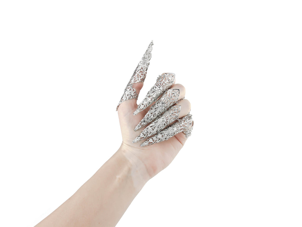 Captured is a full hand set of Myril Jewels claw rings, each piece flowing into long, slender claws that evoke the essence of neo-gothic design. These silver filigree rings, perfect for dark avant-garde enthusiasts, are an impeccable choice for enhancing Halloween attire, gothic-chic fashion, or making a bold statement at rave parties, festivals, or in a drag queen's dazzling ensemble.