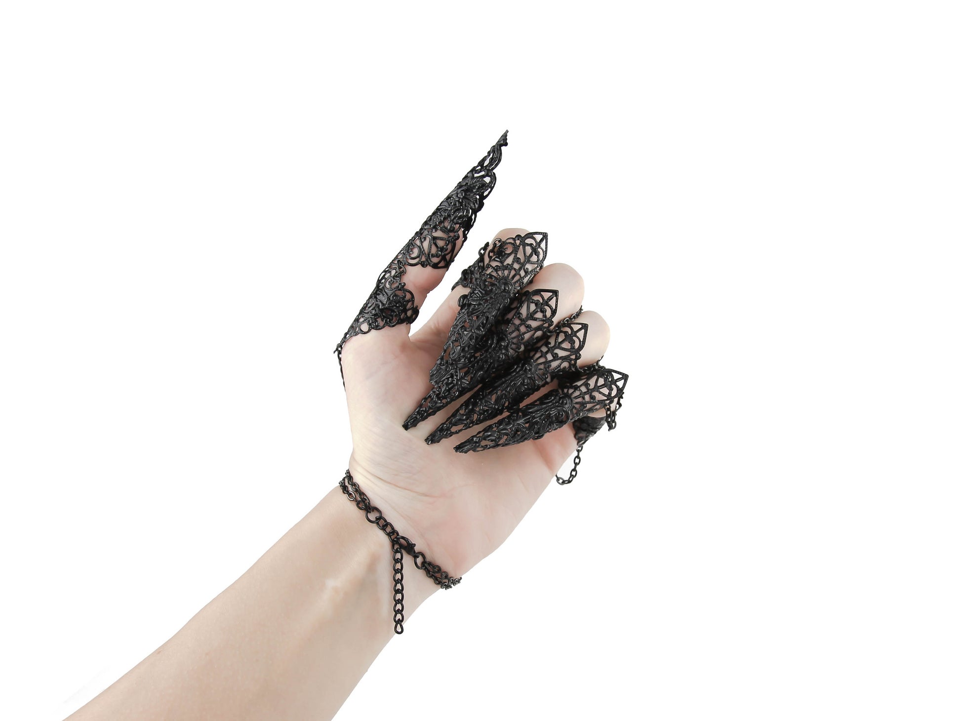 A hand dons a striking goth jewelry piece, the Metal Glove Diablo, with intricate black filigree forming elegant claws, embodying the essence of dark fashion. This statement accessory is perfect for gothic attire, adding a dramatic touch with its ornamental chains and elaborate detailing.