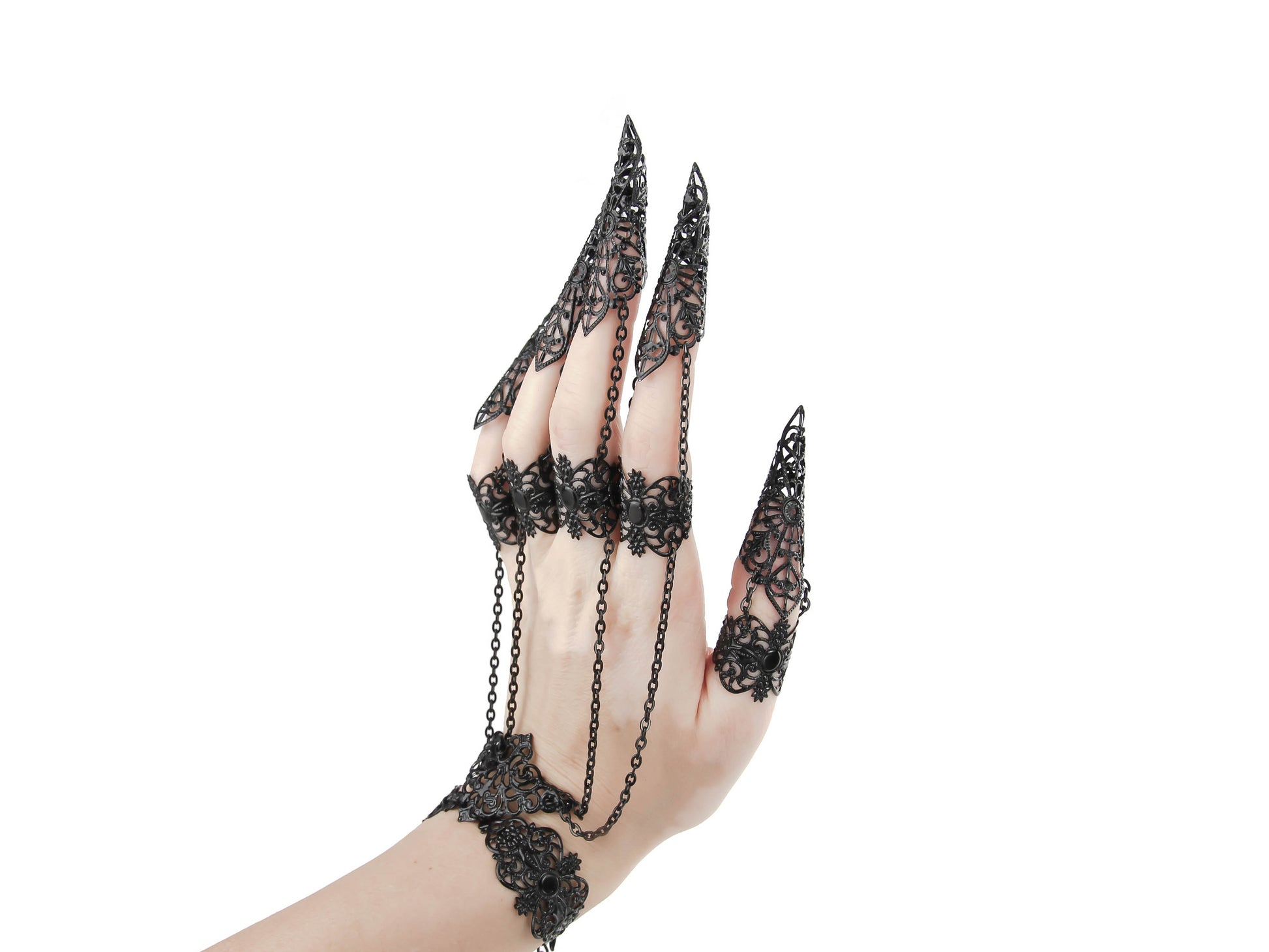 A hand adorned with black claw rings connected by delicate chains to the bracelt part, showcasing a gothic jewelry style with intricate filigree, perfect for a bold gothic or avant-garde fashion statement.