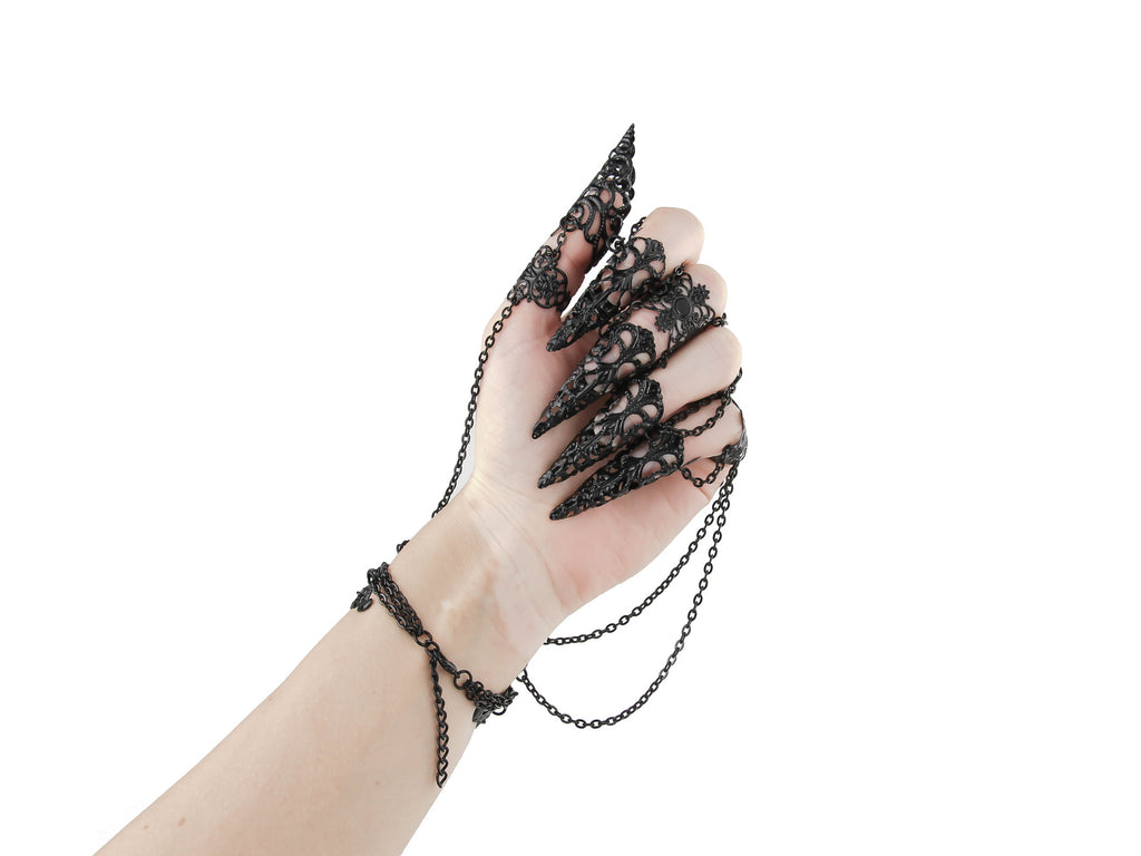An ornate black metal glove with finger claw rings, from Myril Jewels, epitomizes dark avant-garde elegance. Perfect for gothic enthusiasts, this piece is ideal for Halloween, festival wear, or as a distinctive gift, combining boldness with the intricate beauty of neo-gothic jewelry.