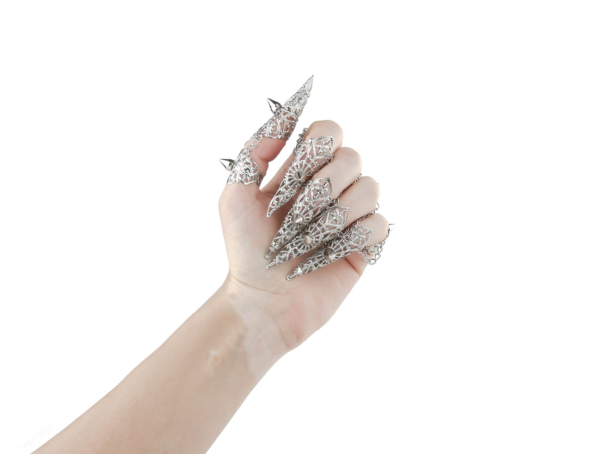 A hand is adorned with a striking set of Myril Jewels silver claw rings, featuring delicate filigree and bold studs. These pieces embody the essence of neo-gothic luxury, perfect for anyone looking to add a touch of dark, avant-garde elegance to their Halloween or everyday gothic-chic style.