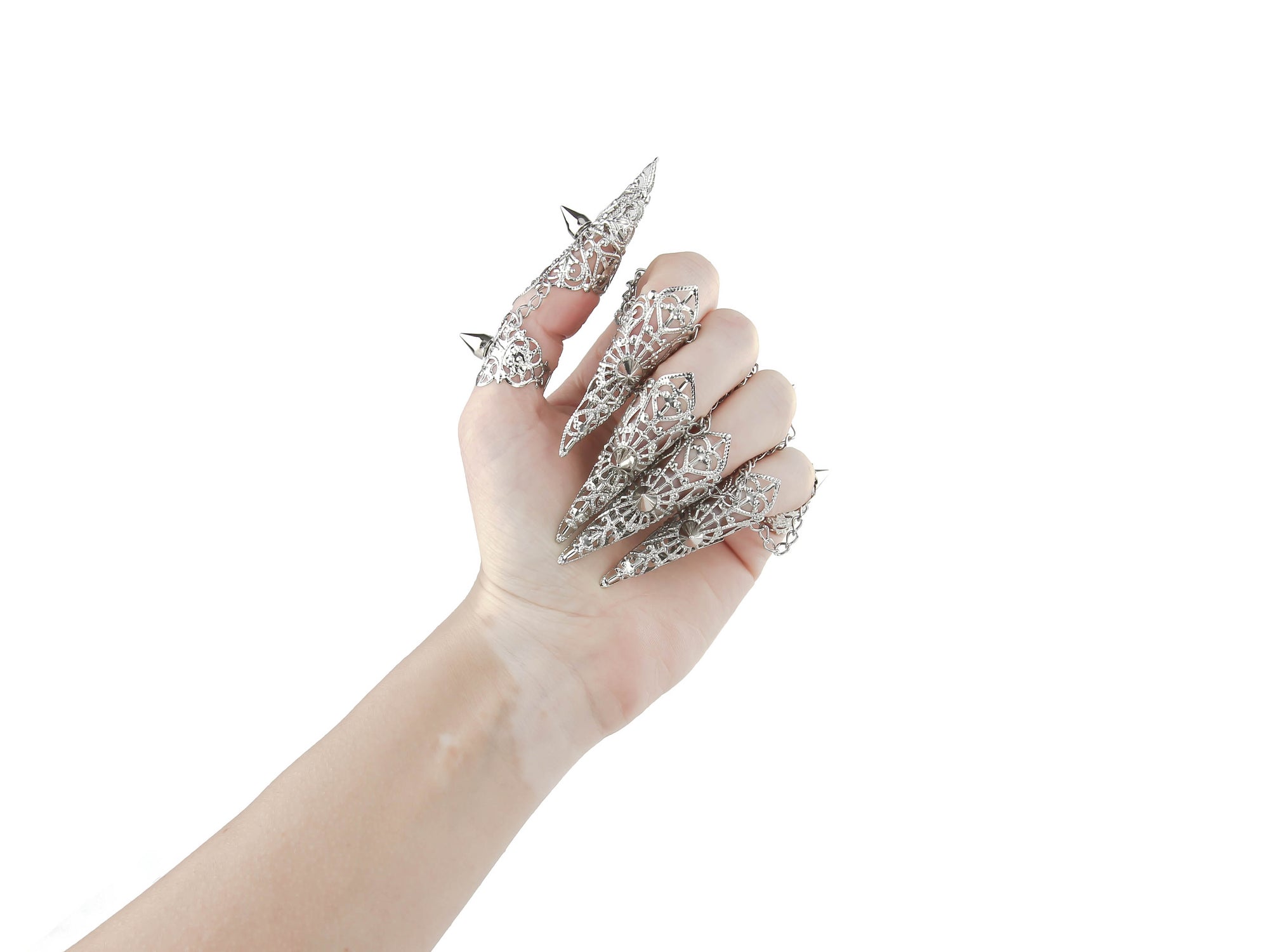 A hand is adorned with a striking set of Myril Jewels silver claw rings, featuring delicate filigree and bold studs. These pieces embody the essence of neo-gothic luxury, perfect for anyone looking to add a touch of dark, avant-garde elegance to their Halloween or everyday gothic-chic style.