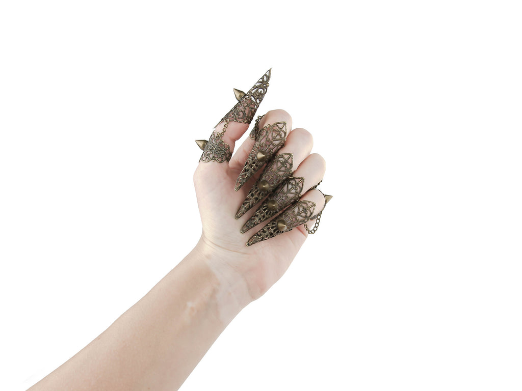 An artistic display of Myril Jewels' bronze claw rings with studs, capturing the essence of neo gothic design. These unique pieces embody the dark avant-garde, suitable for Halloween events, festival wear, or as a bold statement in a gothic-chic wardrobe