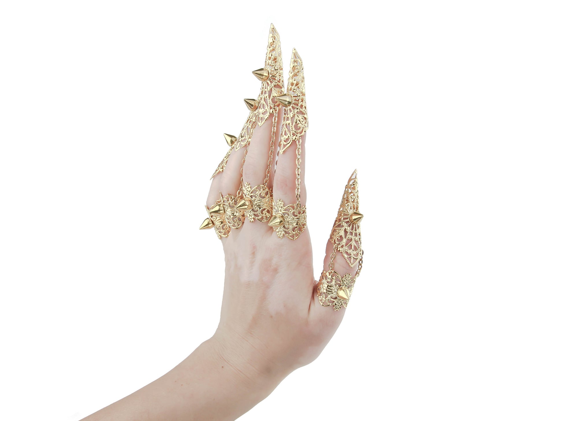 A hand is adorned with a stunning set of Myril Jewels gold claw rings, featuring intricate patterns and bold studs, perfect for a neo-gothic look. Ideal for Halloween, these pieces exemplify gothic-chic and are a dazzling addition to any rave party or festival outfit.