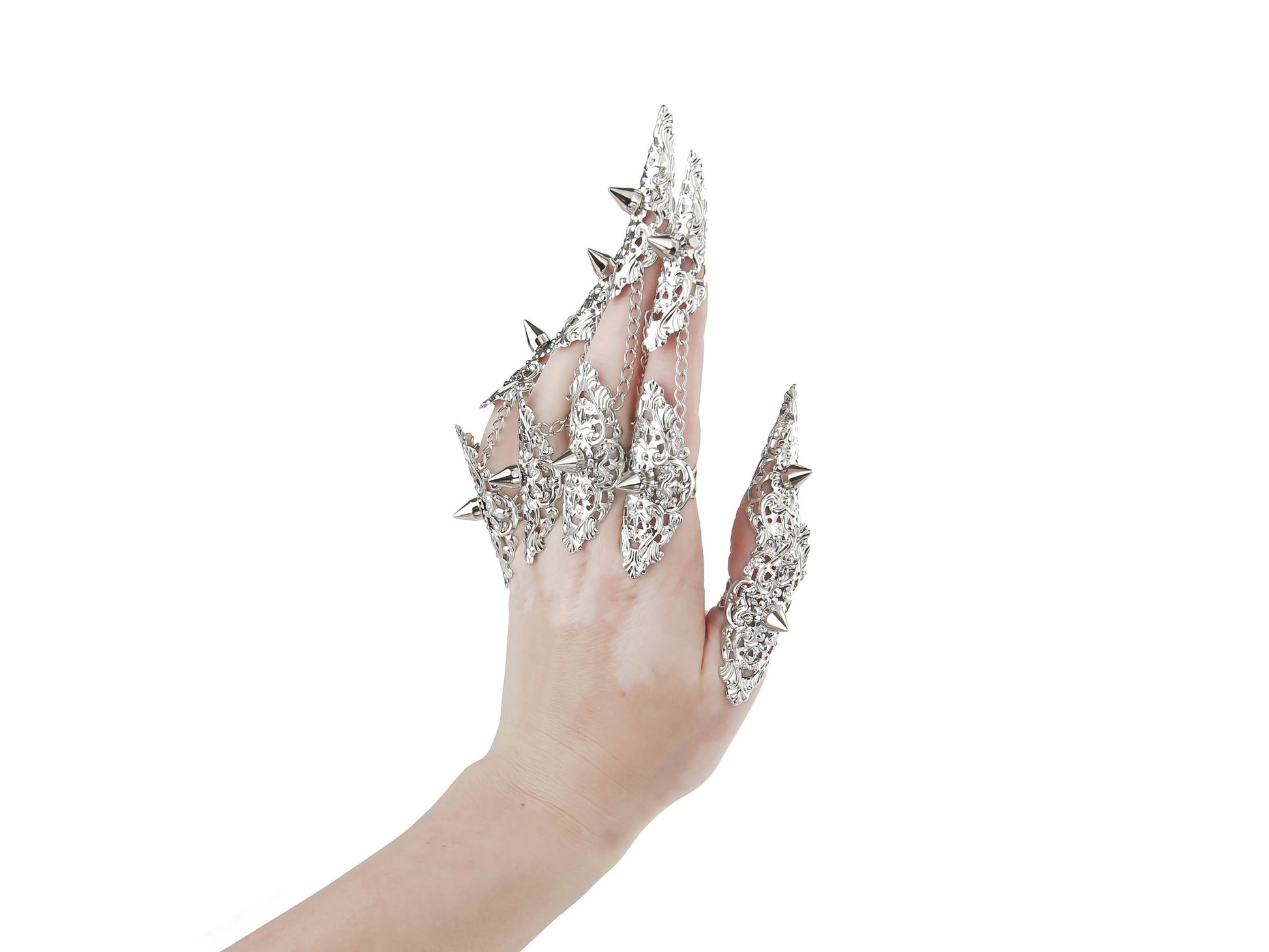  A hand is fully adorned with Myril Jewels' studded nail claw rings, each featuring a detailed silver design with sharp, edgy protrusions. These rings showcase a bold neo-goth aesthetic, perfect for dark-avantgarde fashion enthusiasts. The set is an ideal choice for creating a dramatic look at Halloween events, embodying the gothic-chic and whimsigoth spirit, and is also suited for witchcore, everyday wear, or as statement jewelry for rave parties and festivals.