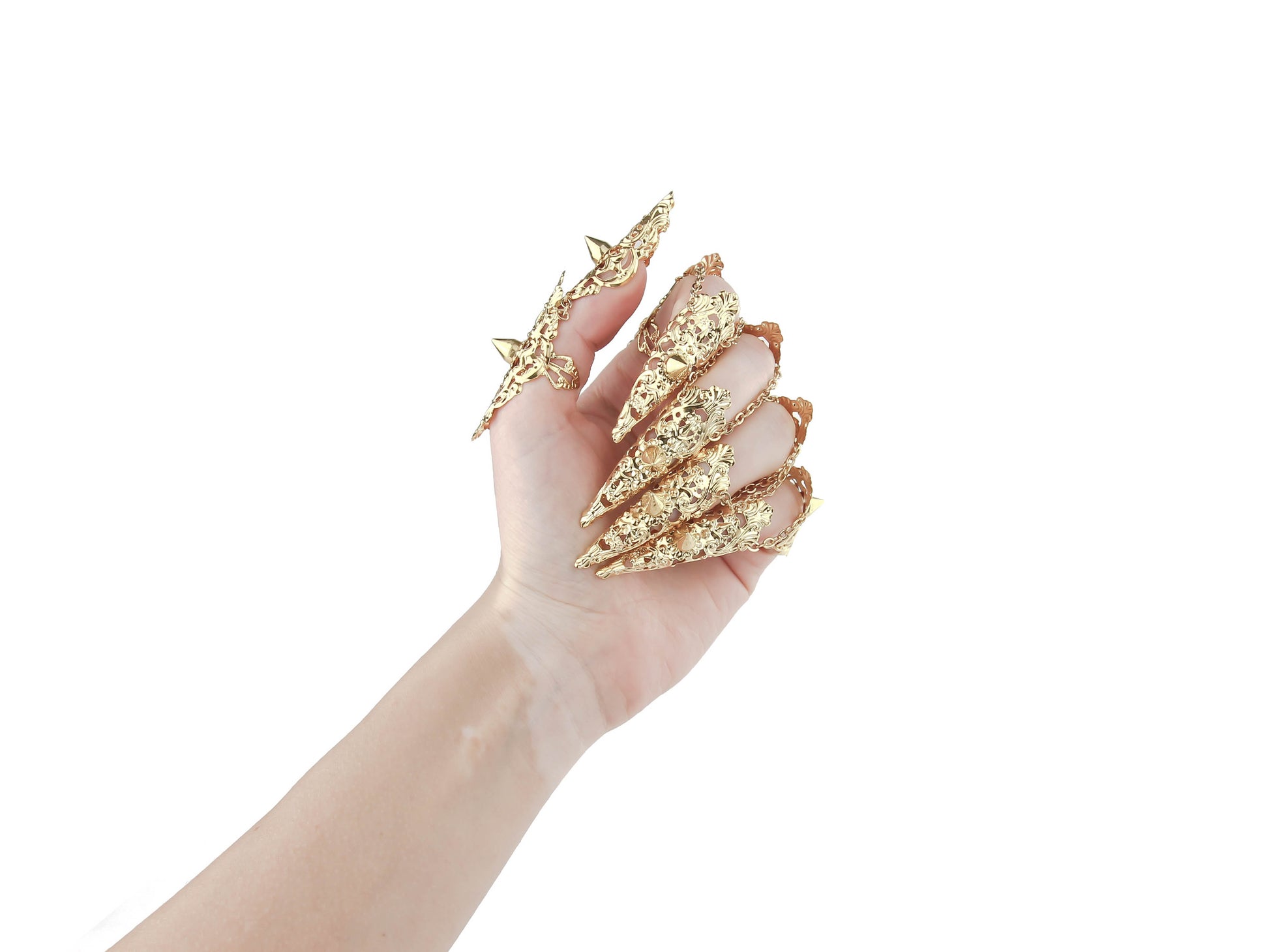 An image captures a hand fully clad in Myril Jewels' studded gold nail claw rings, each piece boasting intricate detailing and sharp studs that epitomize the neo-goth aesthetic. This daring collection is ideal for those who embrace the dark-avantgarde culture, perfect as an edgy accessory for Halloween, punk events, or to add a gothic-chic flair to everyday attire. These rings are a bold statement for witchcore, whimsigoth, or minimal goth styles and will turn heads at any rave party or festival.