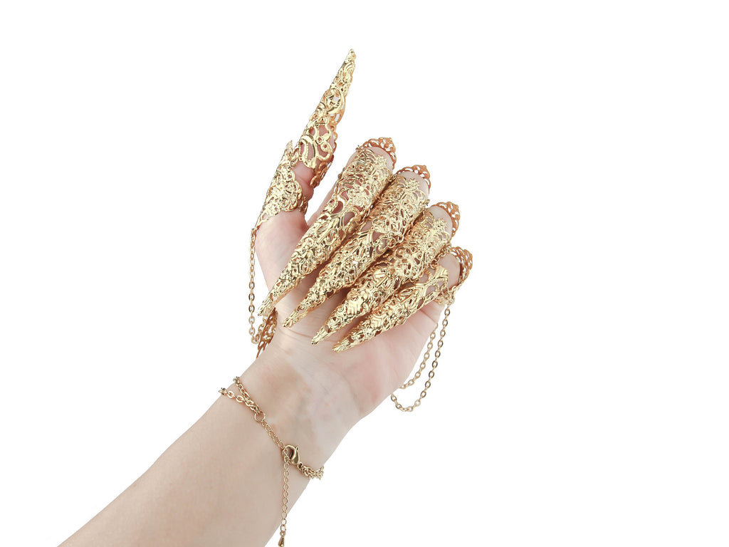A dramatic display of Myril Jewels' gold finger armor rings, intricately designed with a gothic-chic pattern, enveloping the hand in a statement of dark elegance. Ideal for gothic, punk, or witchcore fashion, they're a captivating choice for Halloween and neo-gothic events.