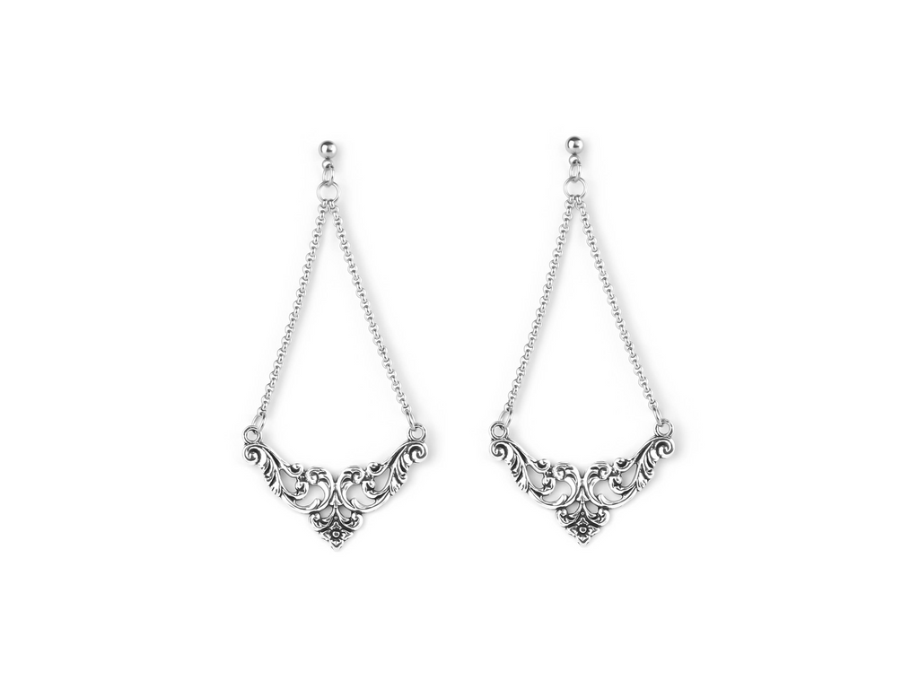 An exquisite pair of Myril Jewels gothic earrings, crafted with silver filigree that forms an elegant, symmetrical design, epitomizing the neo-goth aesthetic. These earrings are a perfect match for individuals who favor gothic-chic and whimsigoth styles, and their timeless elegance makes them suitable for both Halloween and everyday wear, as well as for adding a sophisticated touch to rave party and festival outfits