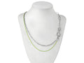 A Myril Jewels punk necklace features on a display, combining silver and vibrant green chains for a striking contrast. The design marries industrial and neo-gothic elements, creating an avant-garde accessory that's ideal for those with a love for gothic-chic and whimsigoth styles. This piece is versatile, suitable for everyday wear, yet bold enough for Halloween, and as a statement piece for rave parties or festivals