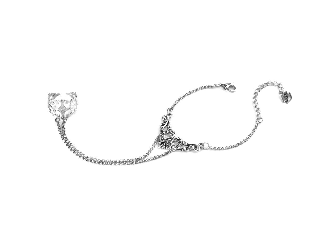 Indulge in the darkly romantic Myril Jewels hand chain bracelet ring, a gothic masterpiece for the avant-garde soul. This filigree ring blooms into a delicate silver chain bracelet, embodying the essence of Neo Gothic jewels and gothic-chic style. Perfect for Halloween, its intricate design is also ideal for daily wear by those who adore the minimal goth look, making a statement at rave parties and festivals alike. A Myril Jewels signature piece for the Whimsigoth and Witchcore enthusiast