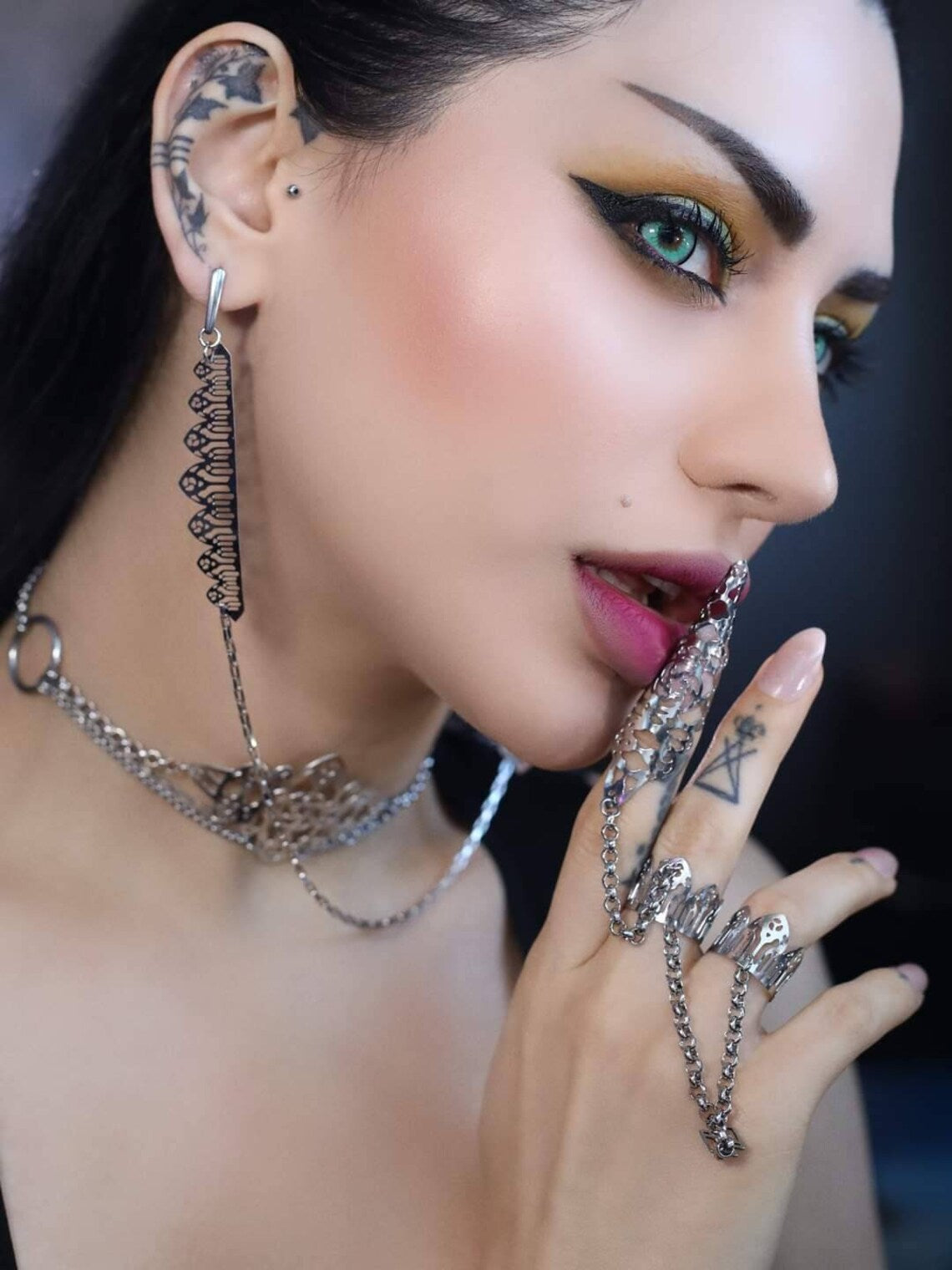 A striking close-up image showcases a model wearing a distinctive double ring from Myril Jewels, designed with claw features and a gothic arch pattern, embodying a dark-avantgarde aesthetic. This bold jewelry piece reflects a fusion of Halloween and punk influences, perfect for gothic-chic enthusiasts and a statement addition to festival or rave party attire. It serves as a unique goth girlfriend gift or a thoughtful friend gift idea, epitomizing everyday wear for those who favor a minimal goth style.