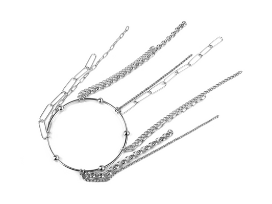  A Myril Jewels rigid bracelet with a large central ring and multiple hanging chains is laid out against a white background. This piece combines the boldness of punk jewelry with the elegance of neo-gothic design, ideal for enhancing a gothic-chic aesthetic or as a distinctive accessory for festivals and everyday wear.