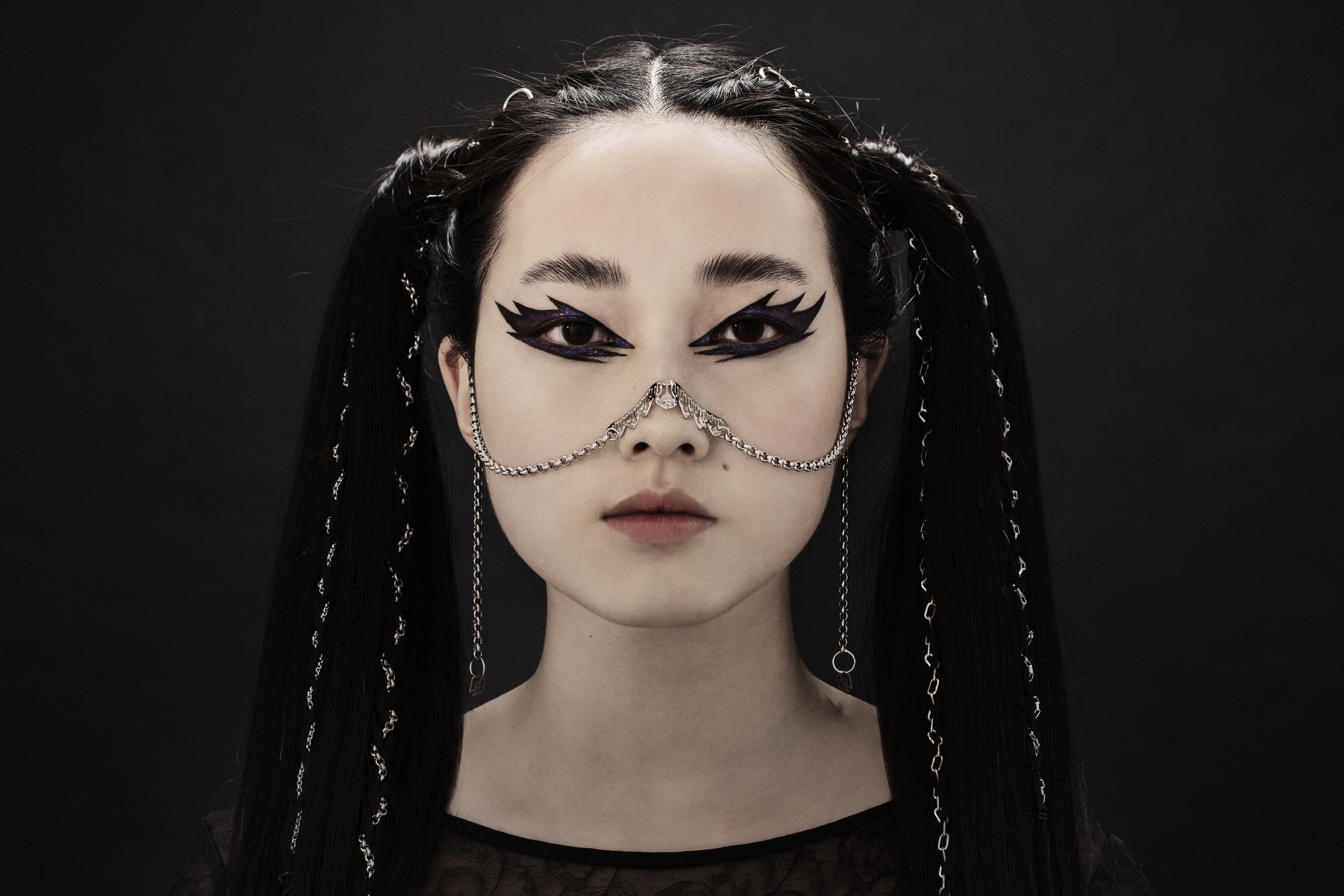 A model exudes dark elegance with a Myril Jewels nose chain, a statement piece evoking neo-gothic and witchcore vibes. Perfect for gothic-chic fashion, it's an ideal accessory for Halloween, festivals, or bold everyday wear, and makes a striking goth girlfriend gift.