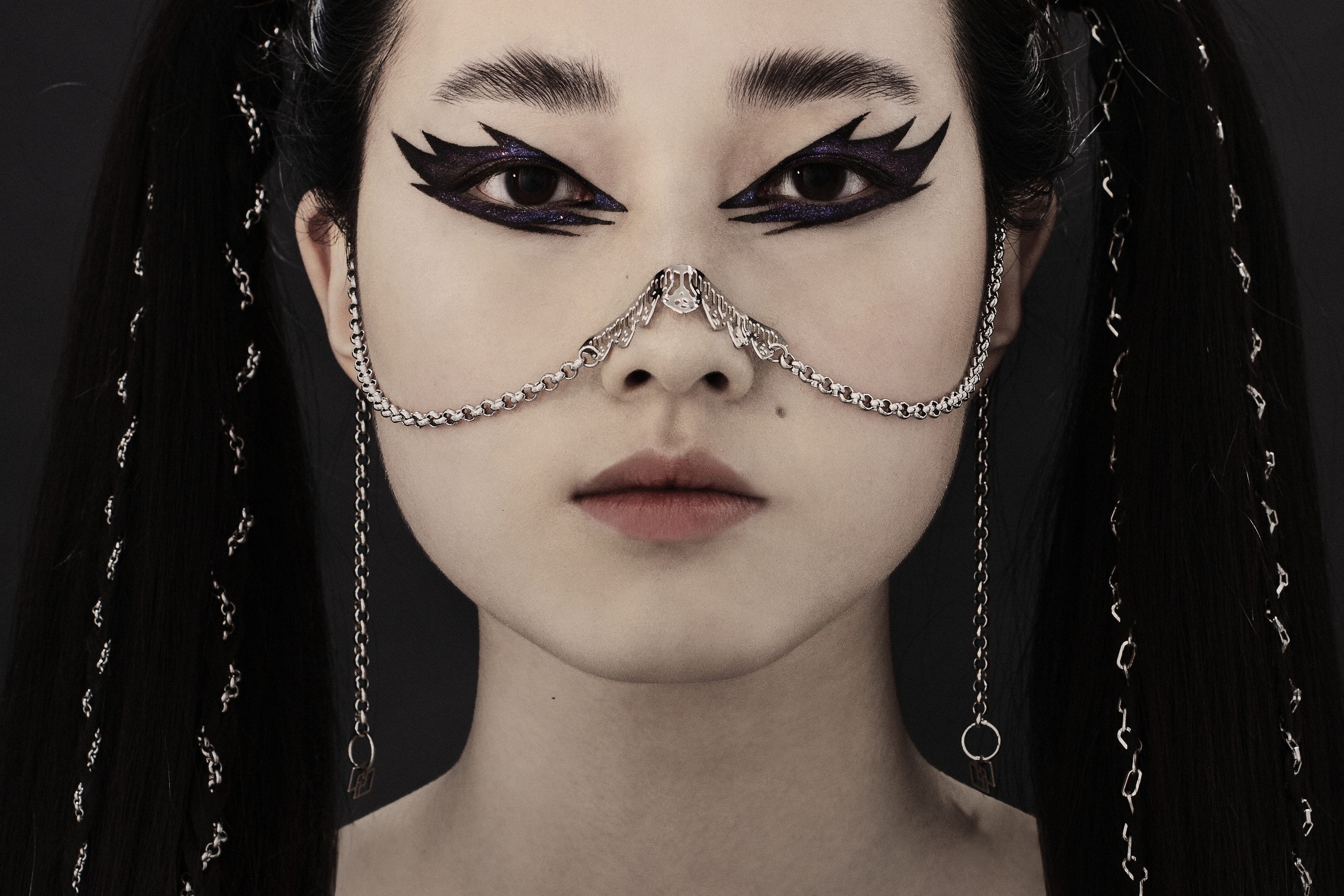 A model presents a sophisticated Myril Jewels nose chain, accentuating gothic-chic style. This piece is a quintessential accessory for those embracing a dark-avantgarde look, perfect for festivals, everyday wear, or as a statement piece for the goth girlfriend.