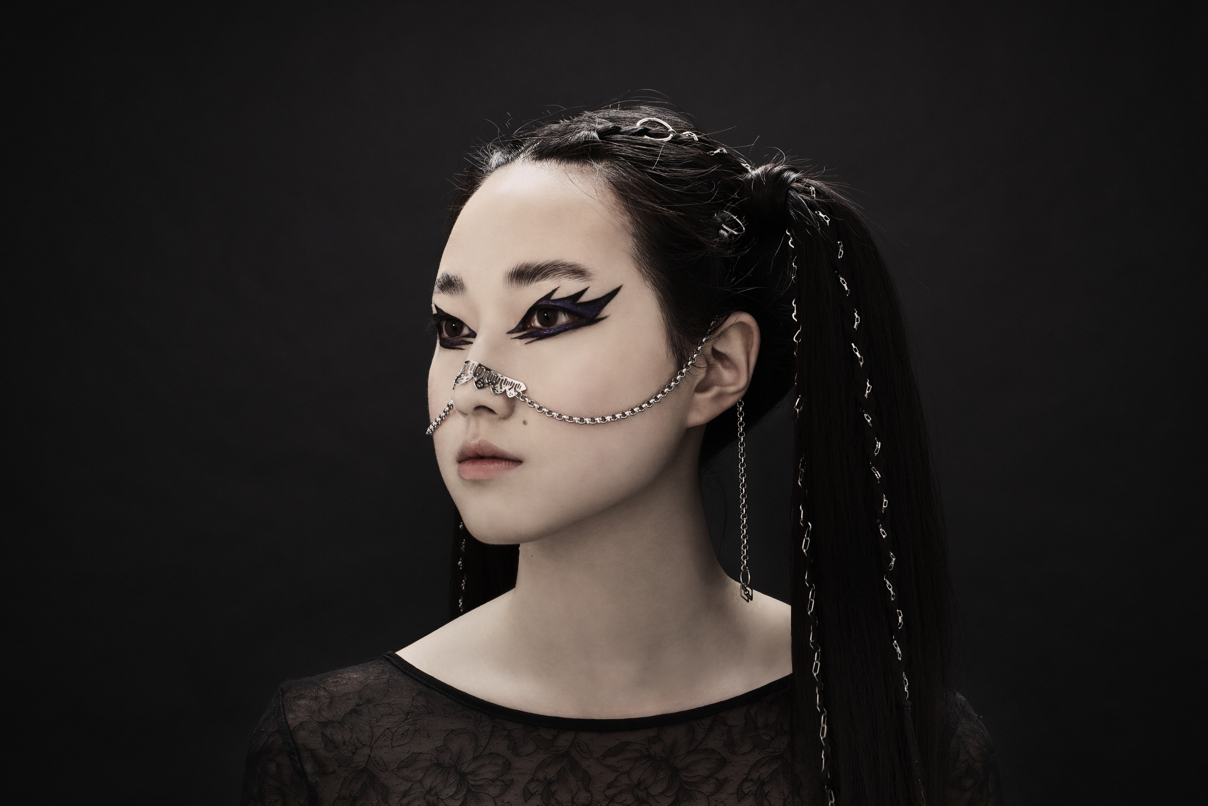 A model presents Myril Jewels' elegant nose chain, embodying the neo-gothic spirit. Perfect for those seeking gothic-chic or Witchcore vibes, this jewelry piece is a striking choice for Halloween, rave parties, or as an everyday symbol of alternative fashion.