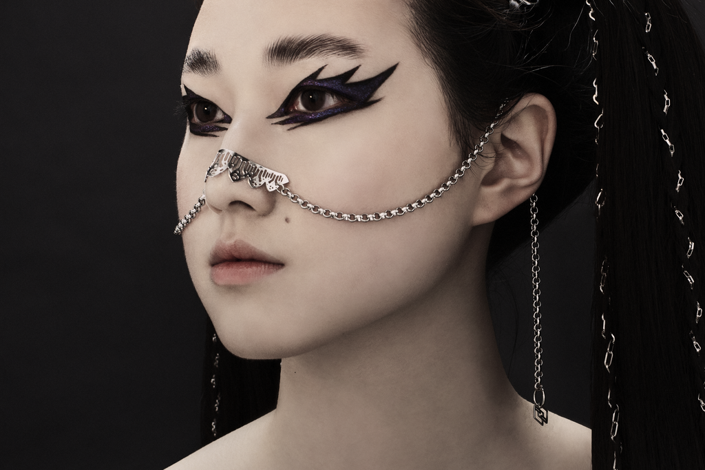 A model exudes dark elegance wearing a Myril Jewels nose chain, a signature piece for gothic and alternative fashion lovers. The chain's intricate design complements a neo-goth aesthetic, perfect for Halloween, festival wear, or as a bold statement in everyday goth attire.