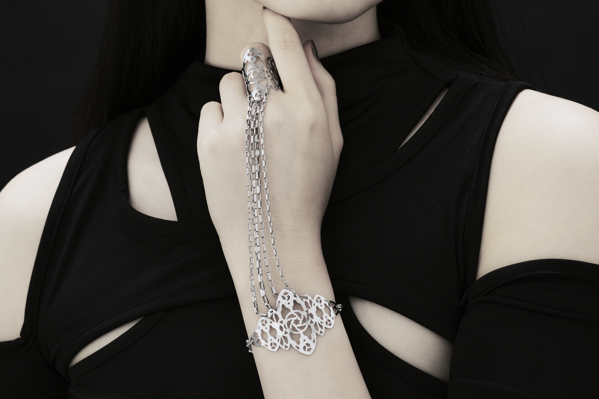 The photo captures a hand elegantly adorned with a Myril Jewels hand chain, featuring intricate gothic arches inspired filigree that cascades down the wrist. It's a perfect blend of neo-gothic style and dark romance, ideal for those who appreciate a touch of avant-garde in their everyday wear or for making a statement at a gothic-chic event.