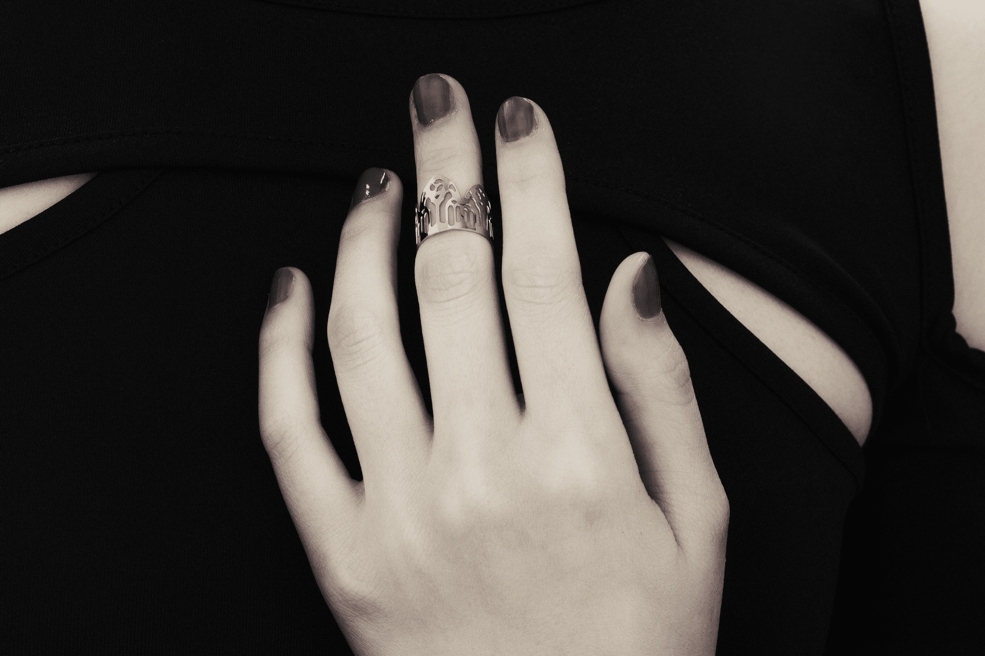 A showcase of Myril Jewels' artisanal, dark-avantgarde midi ring adorning a hand, detailed with complex gothic motifs, perfect for aficionados of gothic and alternative fashion. Crafted with slender bands that echo gothic arches, the ring offers a pronounced display of refined boldness. These pieces, forged in Italy, encapsulate the distinctive, progressive style of Myril Jewels, crafted for the sophisticated palate of the gothic jewelry admirer.