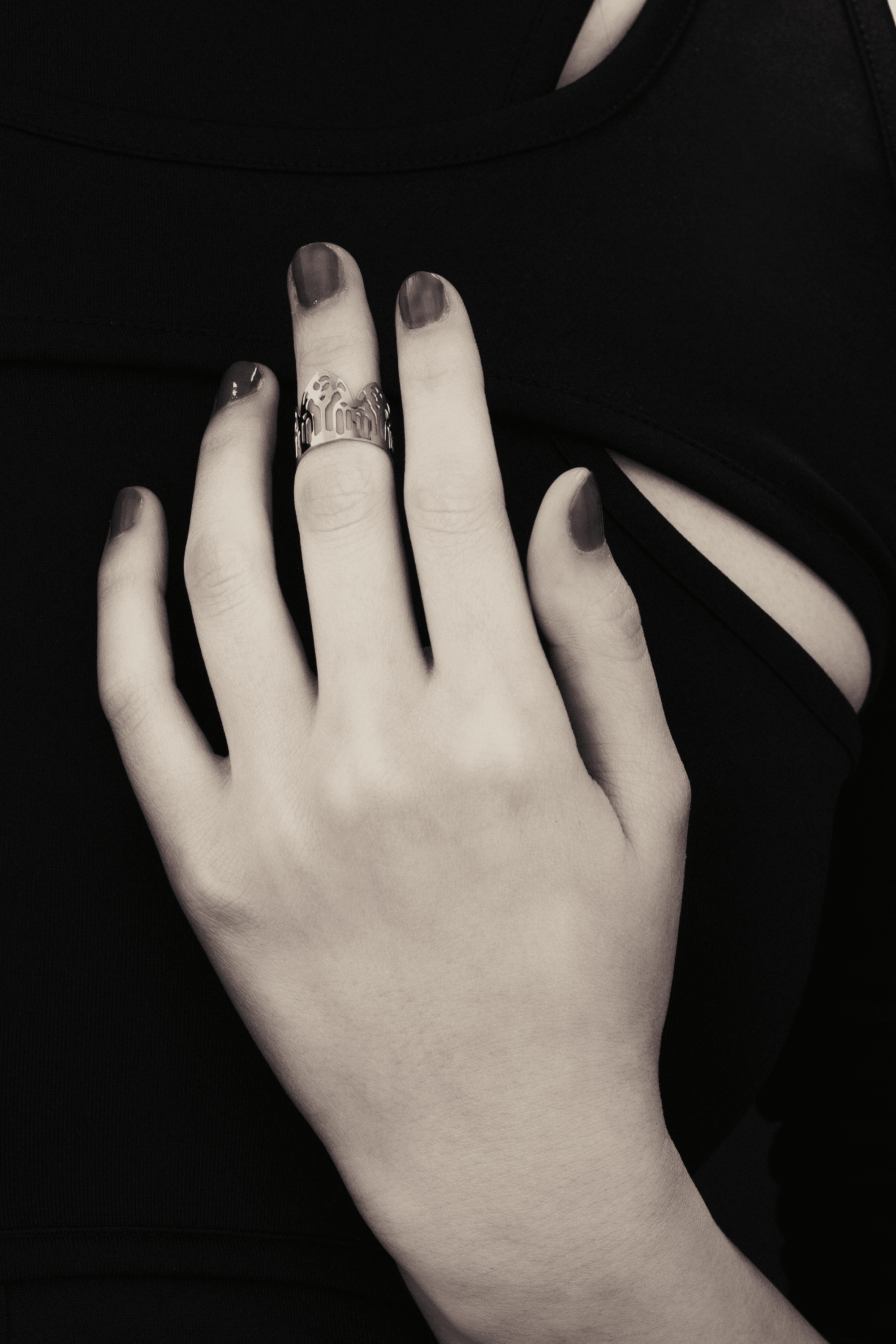 A showcase of Myril Jewels' artisanal, dark-avantgarde midi ring adorning a hand, detailed with complex gothic motifs, perfect for aficionados of gothic and alternative fashion. Crafted with slender bands that echo gothic arches, the ring offers a pronounced display of refined boldness. These pieces, forged in Italy, encapsulate the distinctive, progressive style of Myril Jewels, crafted for the sophisticated palate of the gothic jewelry admirer.