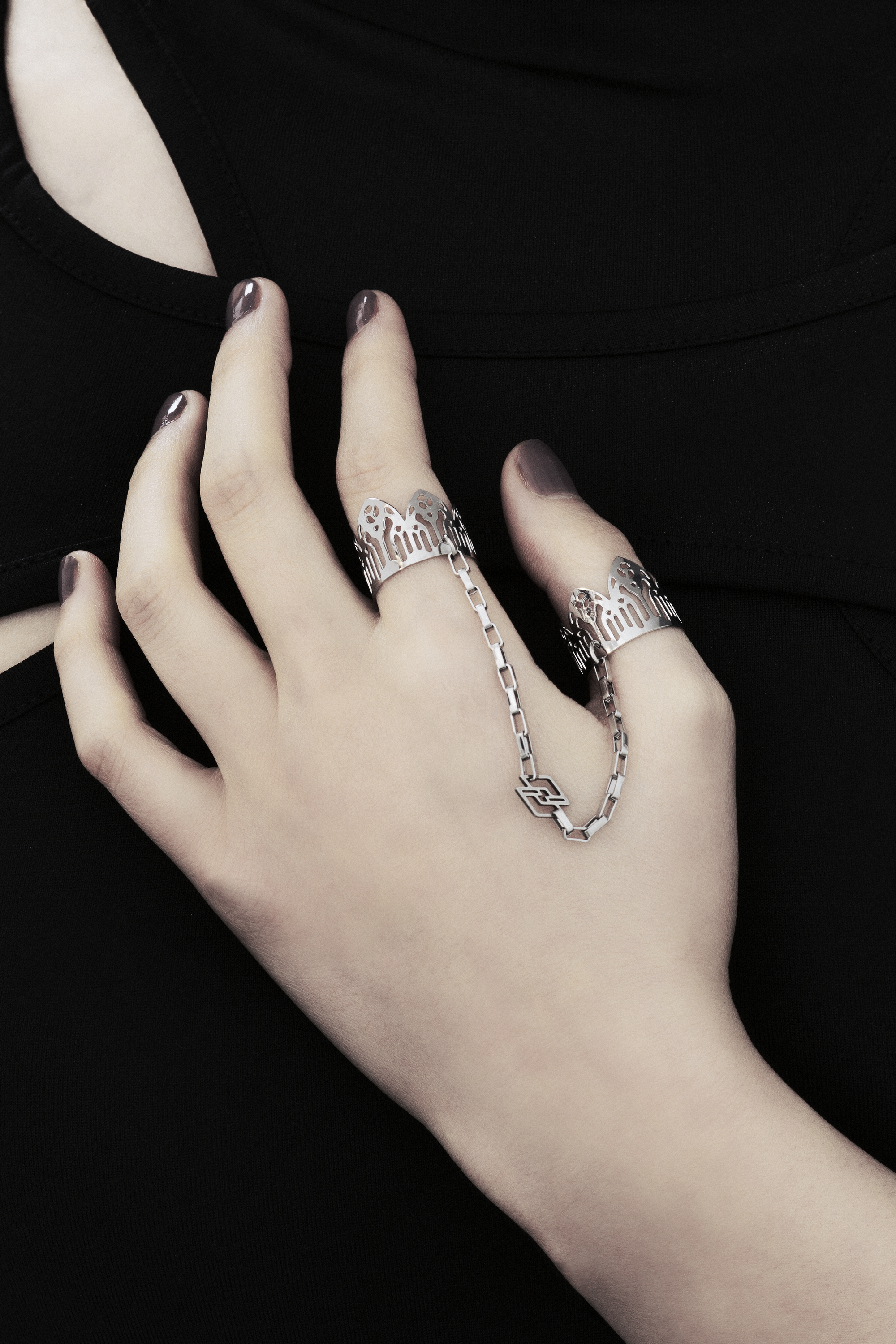 Behold a splendid exhibition of Myril Jewels' hand-wrought, avant-garde double rings, adorned upon a hand. Each ring flaunts elaborate designs inspired by Gothic artistry, catering to aficionados of the gothic and alternative fashion spheres. Crafted with a delicate band that echoes the majestic forms of gothic cathedrals, the rings make a sophisticated statement. These creations, forged in Italy, capture the distinct and dynamic essence of Myril Jewels