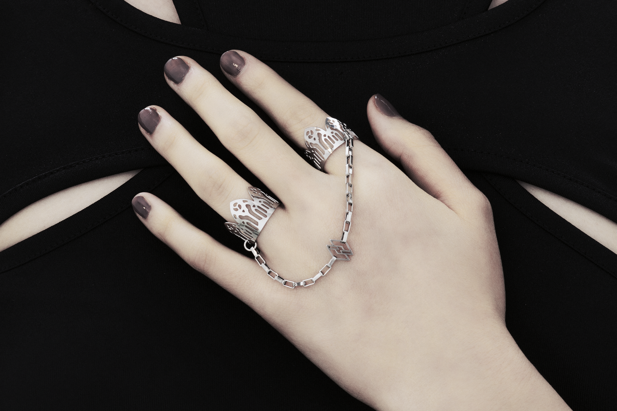 Behold a splendid exhibition of Myril Jewels' hand-wrought, avant-garde double rings, adorned upon a hand. Each ring flaunts elaborate designs inspired by Gothic artistry, catering to aficionados of the gothic and alternative fashion spheres. Crafted with a delicate band that echoes the majestic forms of gothic cathedrals, the rings make a sophisticated statement. These creations, forged in Italy, capture the distinct and dynamic essence of Myril Jewels