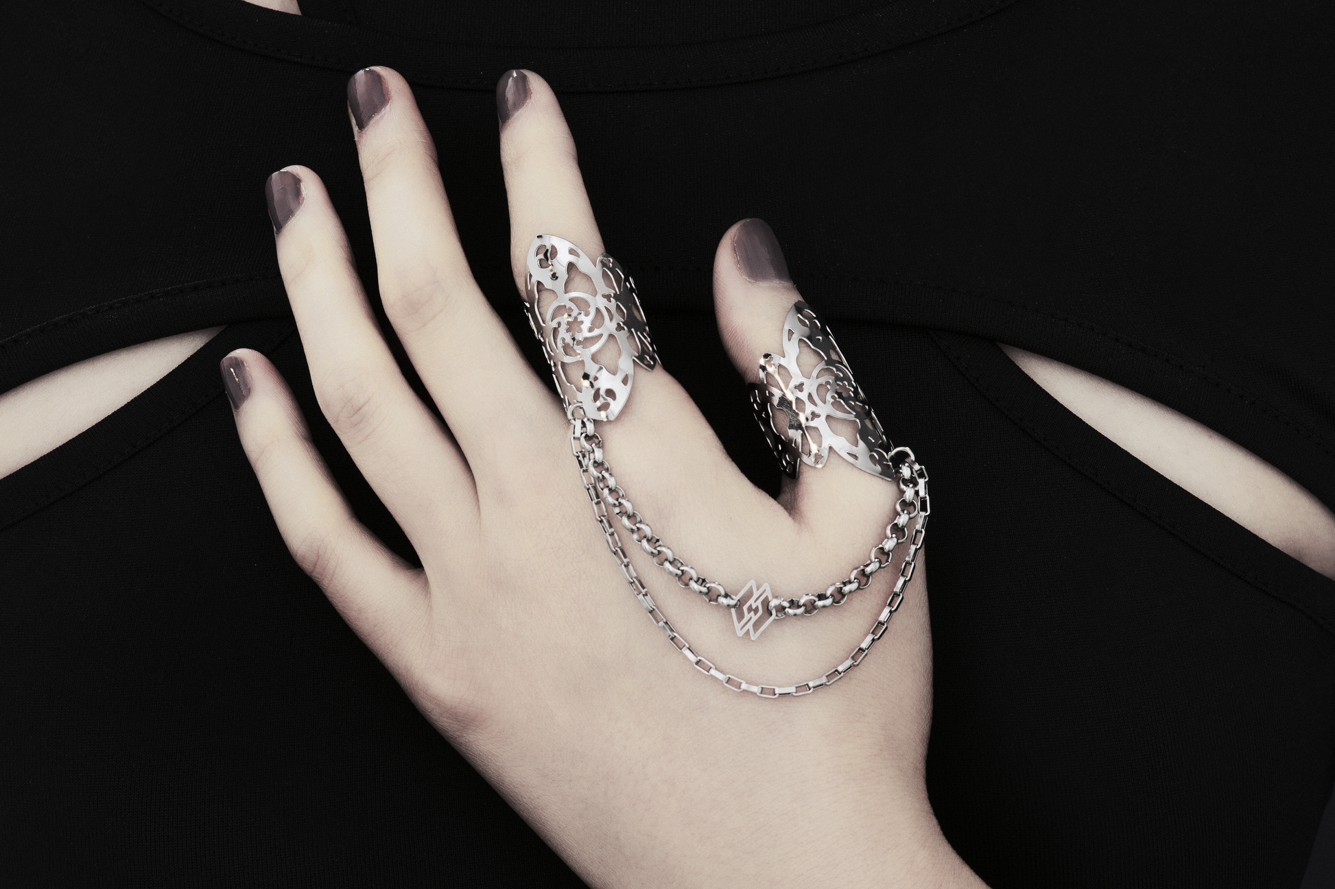 Showcased here is a hand-adorned Myril Jewels double ring, exuding dark sophistication. Crafted with minute gothic details, this piece is perfect for aficionados of the goth and alternative scene. With a design reminiscent of gothic architecture, the slender band proclaims a subtle yet bold elegance. Made in Italy, these rings are a testament to Myril Jewels' distinct and evolving dark avant-garde aesthetic, specifically catered to the refined palate of gothic jewelry admirers.