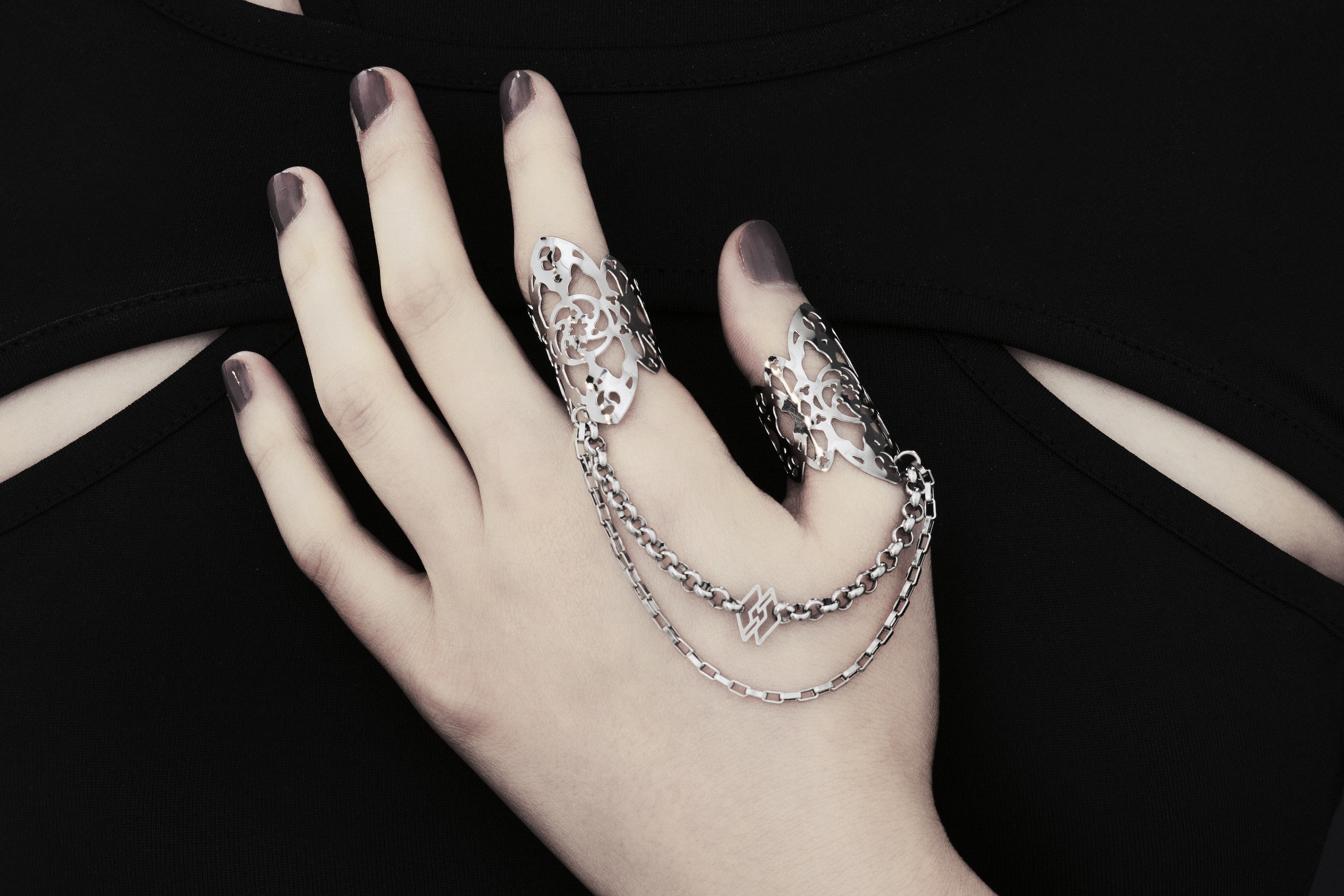 Showcased here is a hand-adorned Myril Jewels double ring, exuding dark sophistication. Crafted with minute gothic details, this piece is perfect for aficionados of the goth and alternative scene. With a design reminiscent of gothic architecture, the slender band proclaims a subtle yet bold elegance. Made in Italy, these rings are a testament to Myril Jewels' distinct and evolving dark avant-garde aesthetic, specifically catered to the refined palate of gothic jewelry admirers.