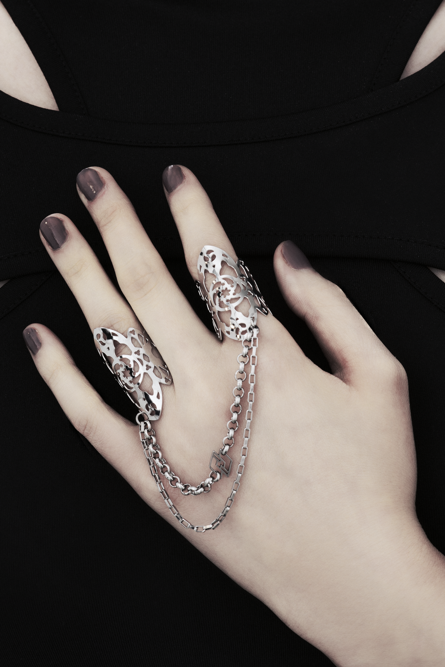 Showcased here is a hand-adorned Myril Jewels double ring, exuding dark sophistication. Crafted with minute gothic details, this piece is perfect for aficionados of the goth and alternative scene. With a design reminiscent of gothic architecture, the slender band proclaims a subtle yet bold elegance. Made in Italy, these rings are a testament to Myril Jewels' distinct and evolving dark avant-garde aesthetic, specifically catered to the refined palate of gothic jewelry admirers.