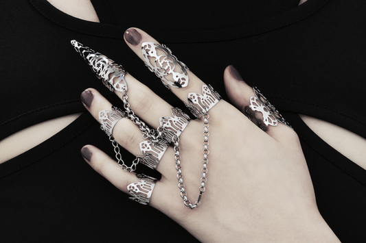 Elegant hand adorned with Myril Jewels' signature dark-avantgarde rings, showcasing intricate gothic patterns linked by delicate chains, reflecting a sophisticated futuristic aesthetic. Perfect for those who embrace a gothic and alternative style, these handmade Italian pieces exemplify Myril Jewels' commitment to evolving dark elegance.
