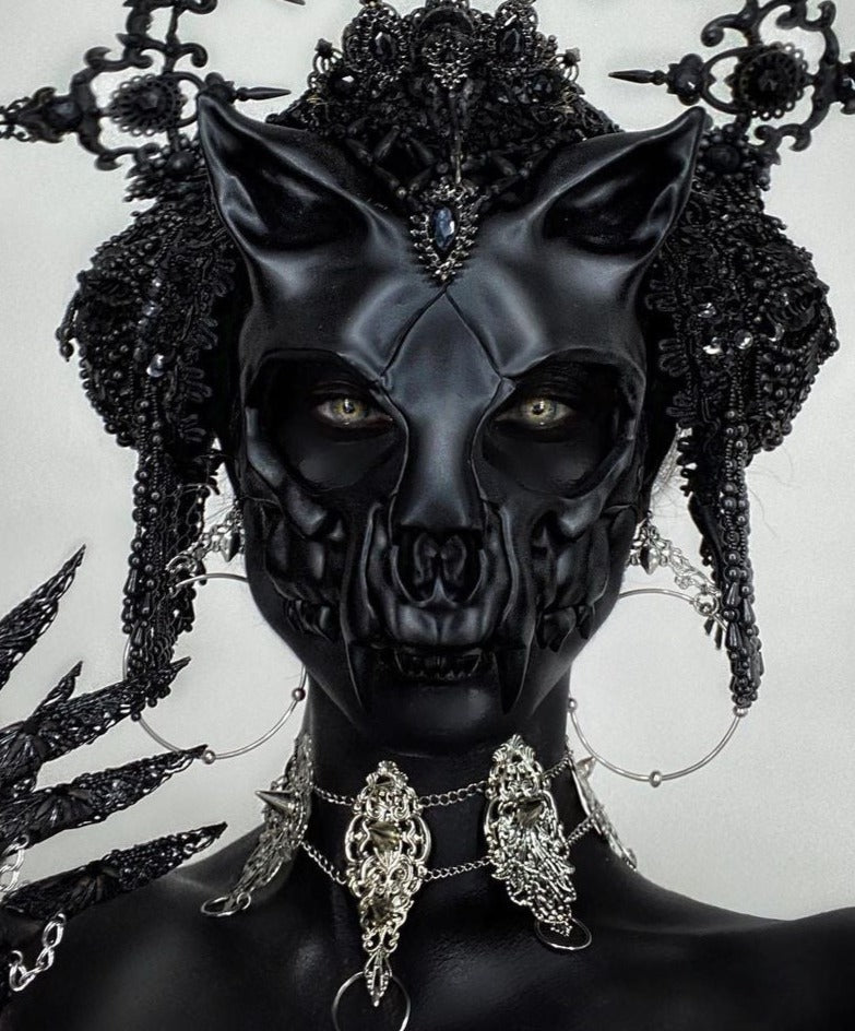 This Myril Jewels punk studded metal choker is a bold statement of dark avant-garde fashion. Adorning a stylized black cat like mask, the choker complements a gothic ensemble, radiating Neo Gothic and Gothic-chic elegance. Ideal for Halloween or everyday wear by those who favor a minimal goth look, it resonates with the alternative style community. The piece exudes whimsigoth charm and witchcore mystique, perfect for lovers of unique and handcrafted jewelry
