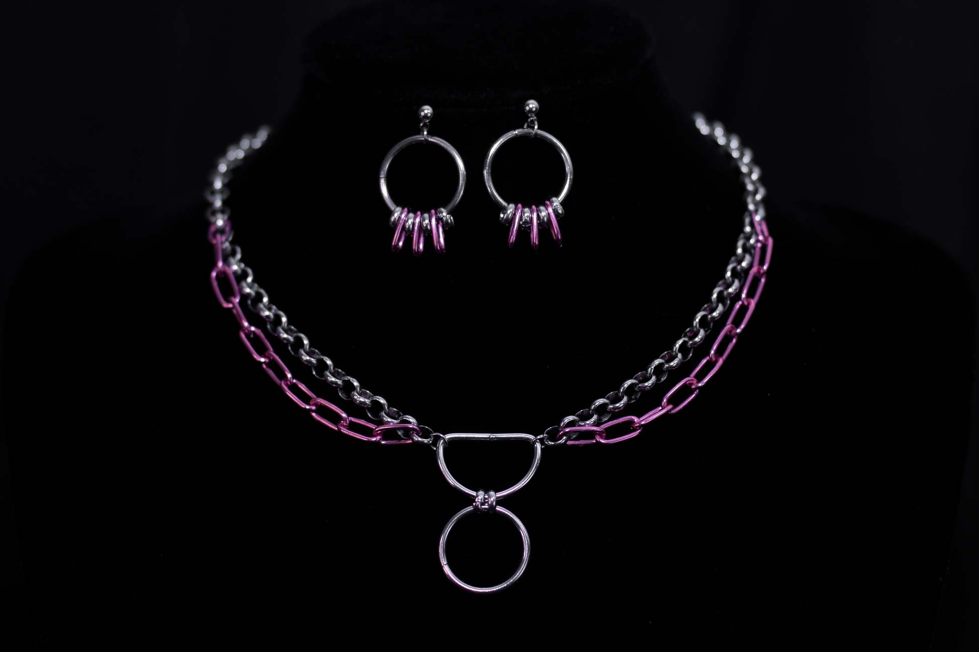 Showcasing Myril Jewels' signature neo-gothic flair, this image features small silver hoop earrings with vibrant pink accents, complemented by a matching layered chain necklace. Ideal for a goth girlfriend gift, these pieces are perfect for adding a bold statement to everyday wear or special events like festivals