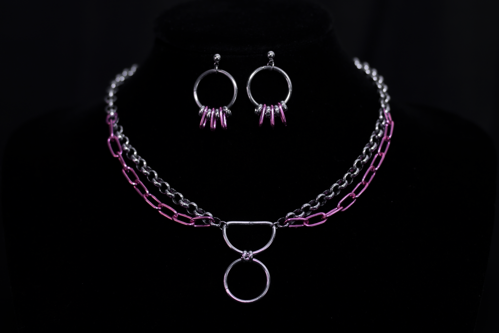 Showcasing Myril Jewels' signature neo-gothic flair, this image features small silver hoop earrings with vibrant pink accents, complemented by a matching layered chain necklace. Ideal for a goth girlfriend gift, these pieces are perfect for adding a bold statement to everyday wear or special events like festivals