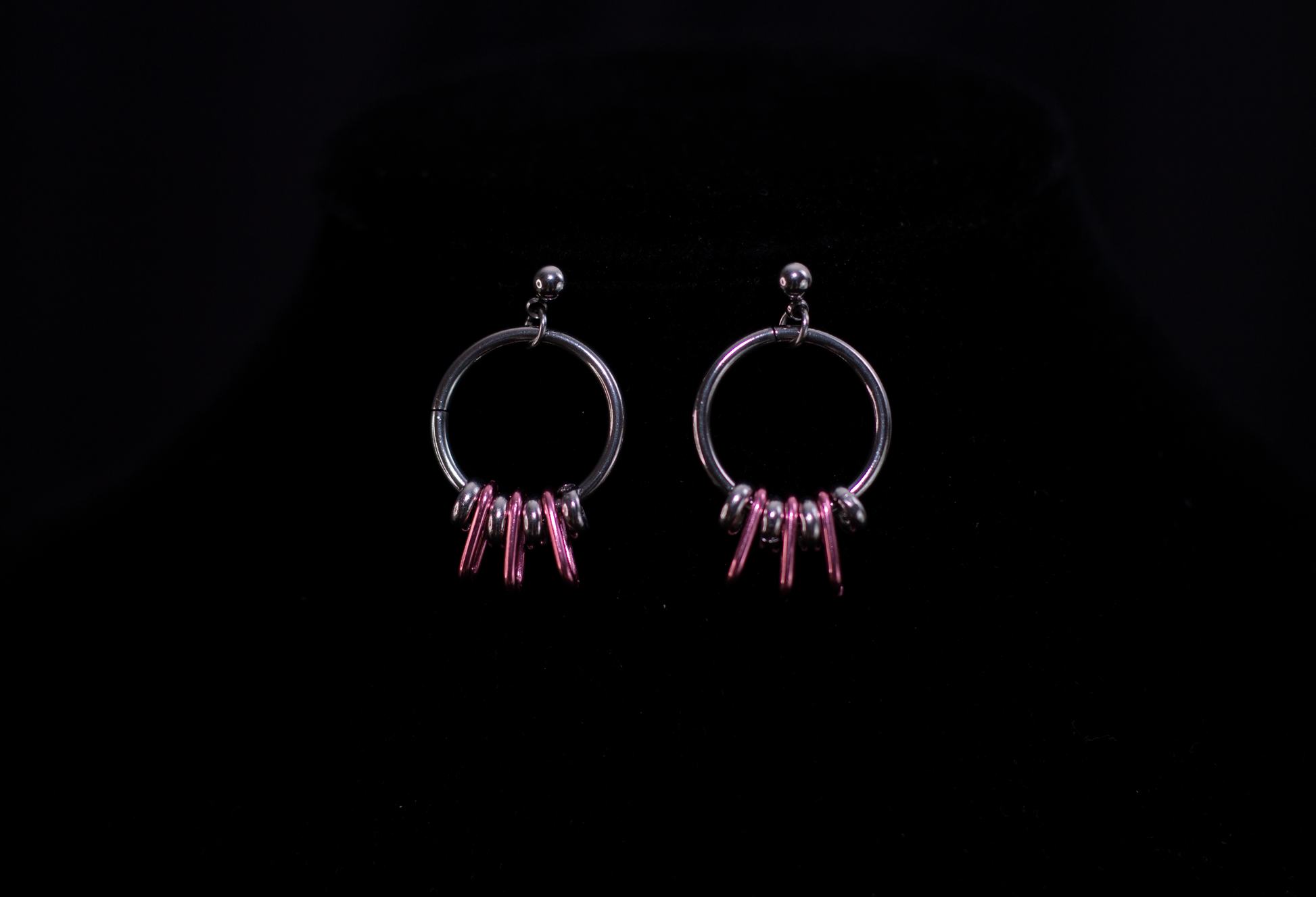 Accentuate your look with Myril Jewels' chic silver hoop earrings, featuring elegant pink accents for a touch of color. Perfect for gothic style enthusiasts, these earrings are a versatile addition to both edgy and minimalist outfits, ideal for daily wear or as a distinctive gift.