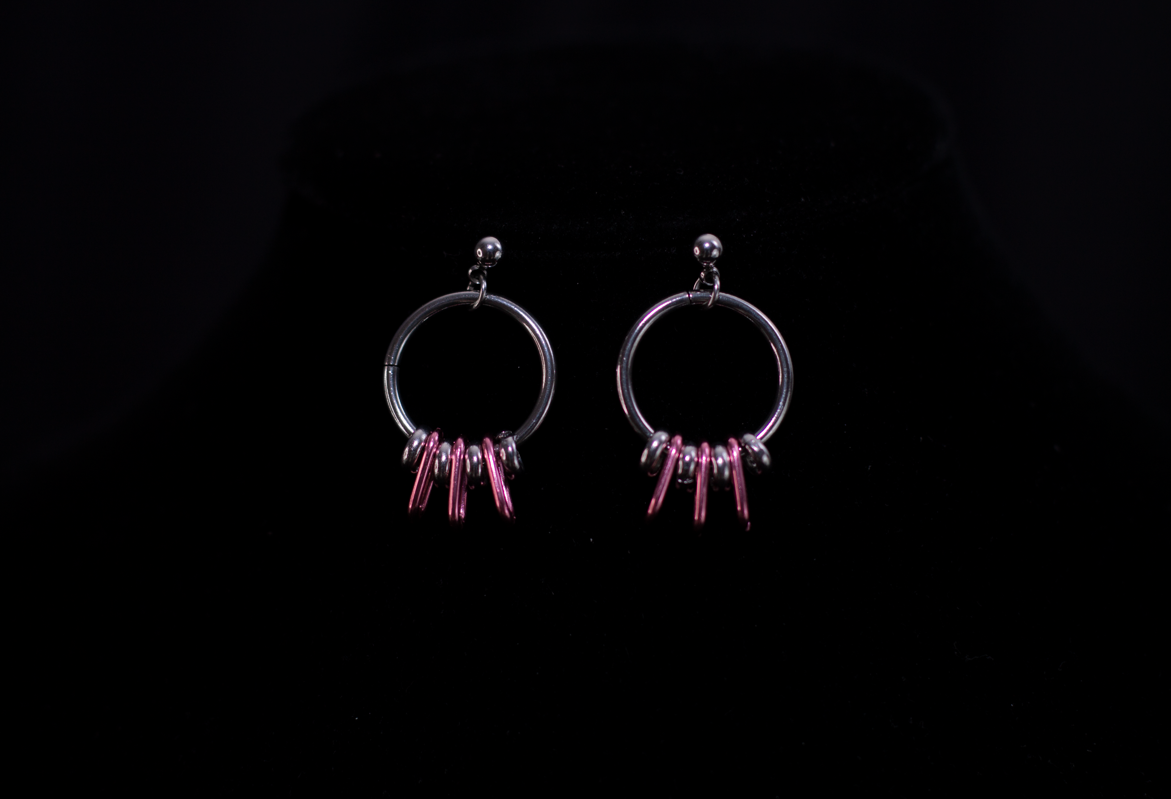 Accentuate your look with Myril Jewels' chic silver hoop earrings, featuring elegant pink accents for a touch of color. Perfect for gothic style enthusiasts, these earrings are a versatile addition to both edgy and minimalist outfits, ideal for daily wear or as a distinctive gift.