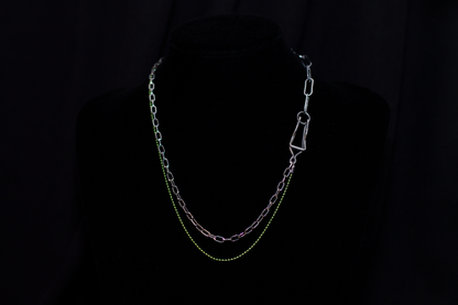  This image showcases a Myril Jewels punk-inspired silver and green chain necklace, artfully displayed on a dark mannequin. The necklace features a mix of classic and oversized links, with a striking green hue that adds a pop of color to the overall dark-avantgarde aesthetic. It's a versatile piece that aligns with neo-gothic trends and caters to gothic, whimsigoth, and witchcore styles, making it a fitting accessory for Halloween, everyday minimal goth fashion, rave parties