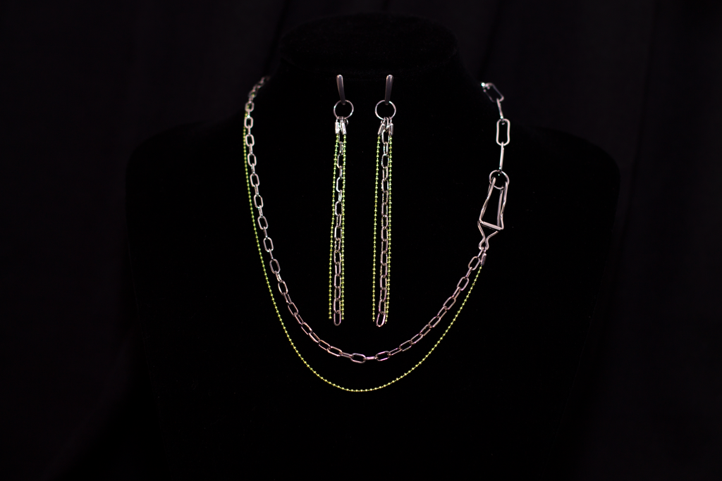 An exquisite Myril Jewels set, featuring neo-gothic long-chain earrings and a matching necklace, perfect for goth and alternative fashion enthusiasts. The silver links are accented with vibrant green beads, encapsulating a gothic-chic vibe. This bold jewelry set serves as a statement piece for rave parties or as a distinct goth girlfriend gift, embodying the whimsigoth and witchcore essence in every detail.