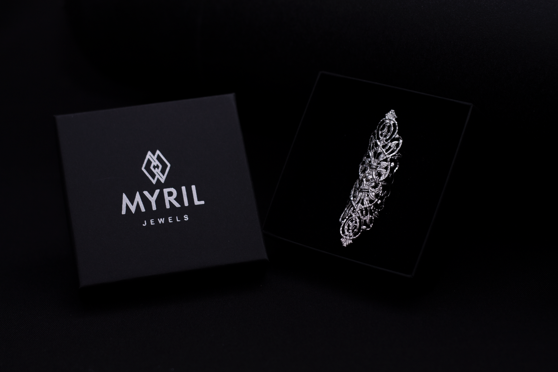 Dramatic wide gothic ring by Myril Jewels presented in its packaging with the brand's logo for a distinct dark-avantgarde appeal. This neo-gothic masterpiece, ideal for Halloween or as a punk fashion statement, exudes gothic-chic and whimsigoth style, perfect for a goth girlfriend gift or bold everyday wear.