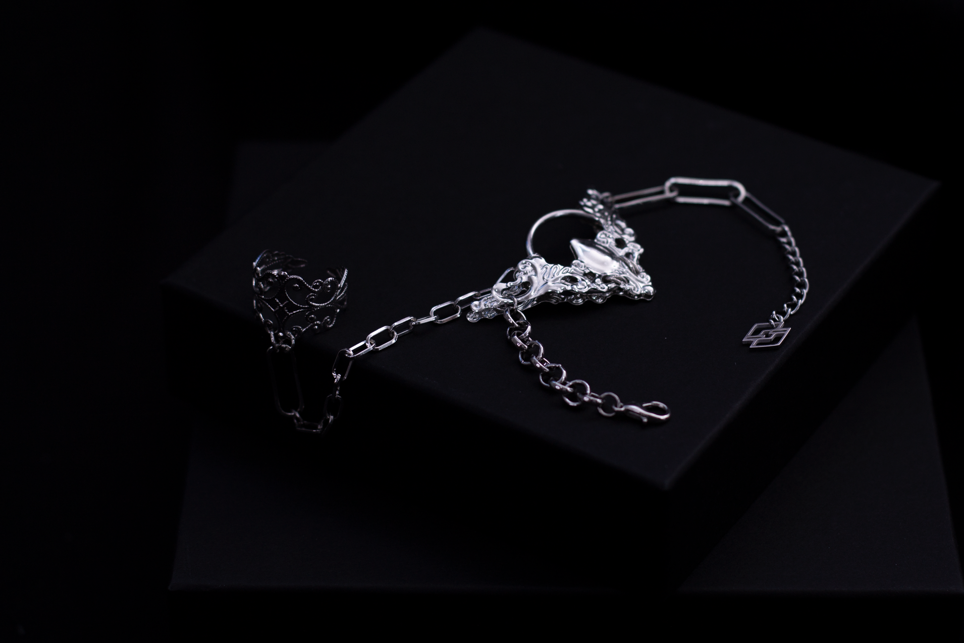 Myril Jewels presents a hand chain bracelet ring, set against a black background, that combines neo-gothic intricacy with punk accents, perfect for avant-garde jewelry aficionados