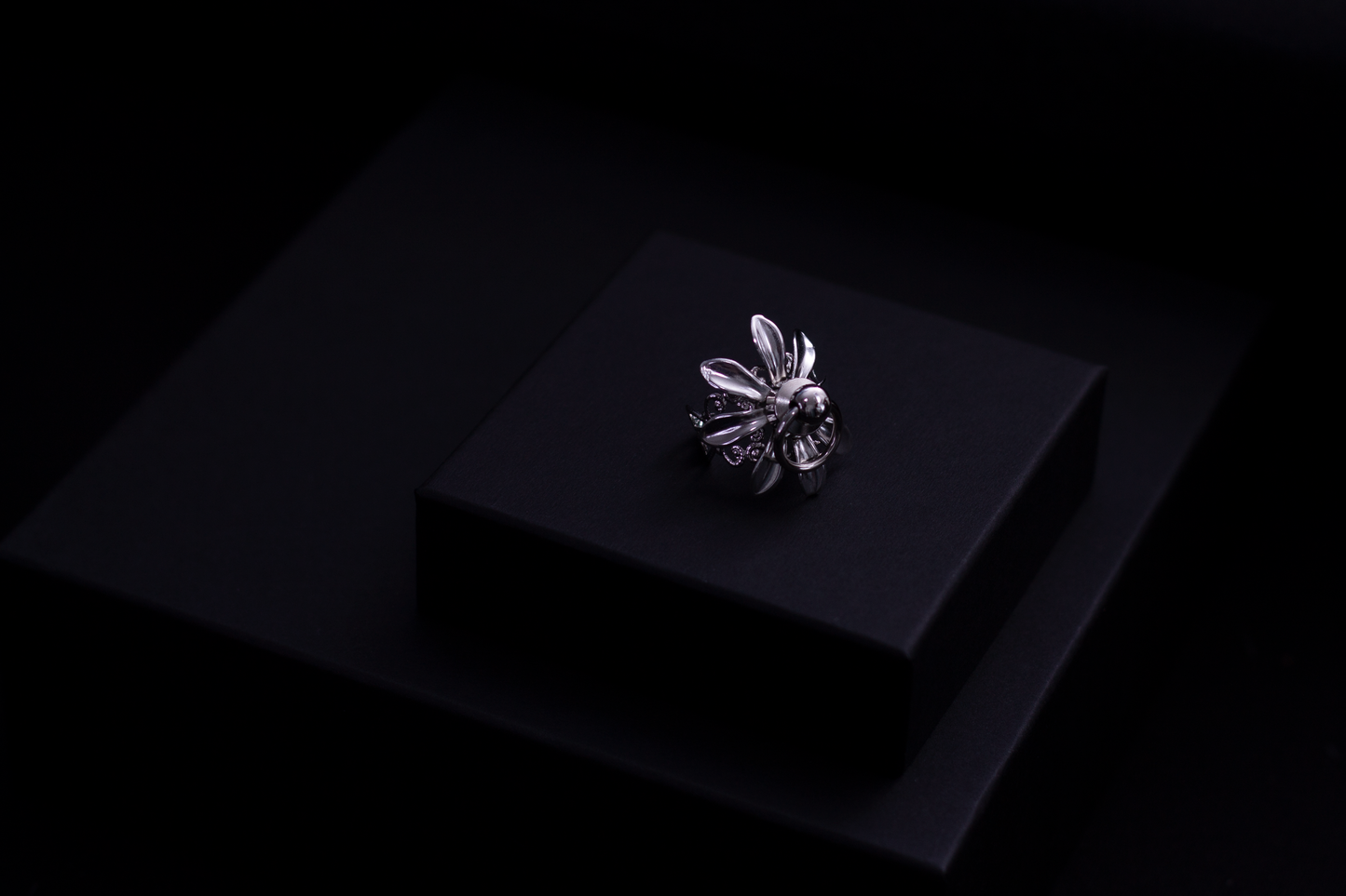 A Myril Jewels signature Flower ring, with its lustrous silver finish and gothic design, is elegantly placed atop a matte black presentation box. This image encapsulates the dark-avantgarde essence of the brand, catering to those with a taste for distinctive, alternative jewelry.
