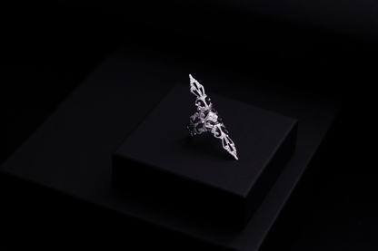 A sleek Myril Jewels' ring on a dark surface, revealing a sophisticated silver filigree expressing the brand's refined gothic jewelry collection.