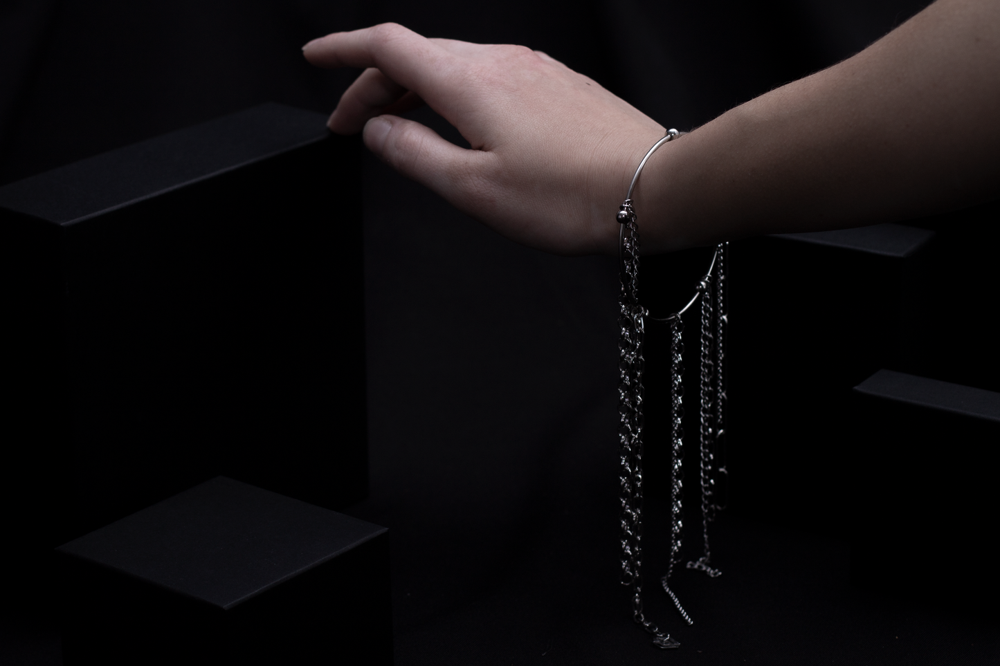 This image features a Myril Jewels rigid bracelet with multiple hanging chains, creating a striking statement piece. This bracelet reflects a neo-gothic aesthetic with its blend of elegance and edge, suitable for a variety of looks from everyday wear to more dramatic festival or Halloween ensembles.