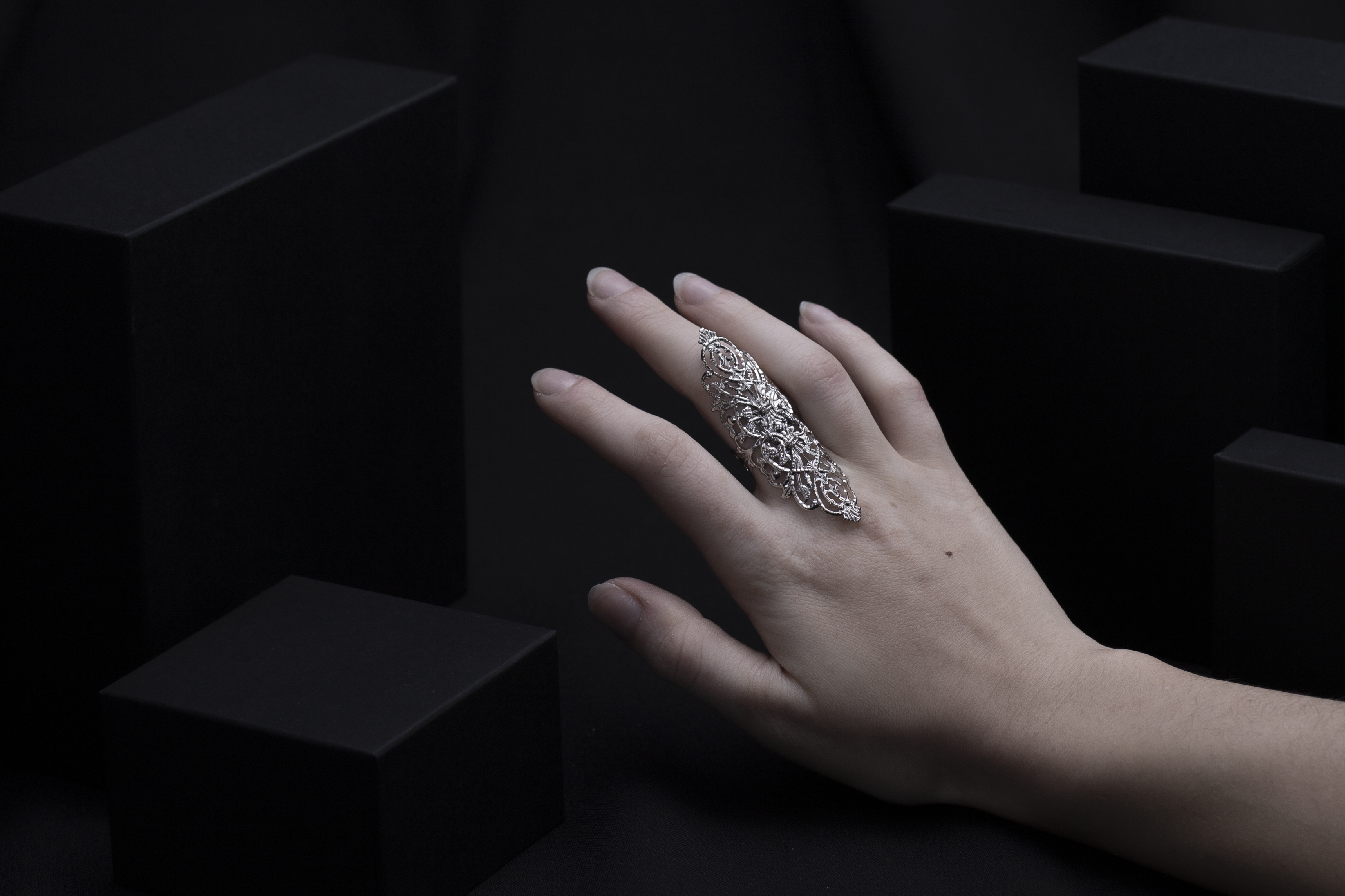 A luxurious wide gothic ring by Myril Jewels adorns a finger, embodying the spirit of dark-avantgarde elegance. Its intricate neo-gothic design is perfect for those embracing gothic-chic or whimsigoth styles. Ideal for daily minimal goth flair or as an eye-catching accessory at any rave or festival, this piece makes a thoughtful goth girlfriend or friend gift.