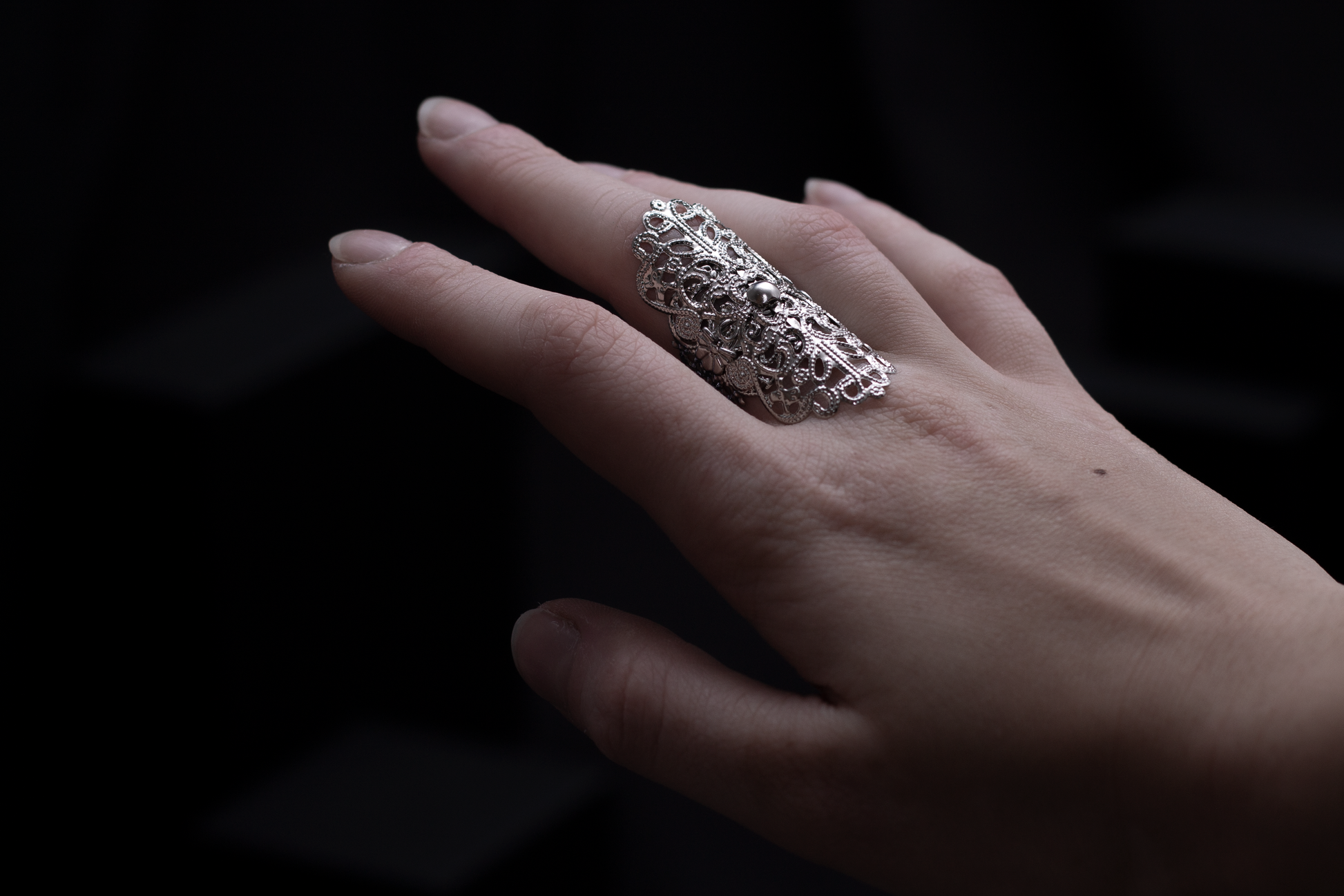 A hand models an oval gothic ring by Myril Jewels, showcasing delicate filigree details perfect for gothic-chic fashion lovers. This bold, handcrafted piece makes a statement as everyday wear, festival jewelry, or as a distinctive goth girlfriend gift, embodying a dark avant-garde aesthetic