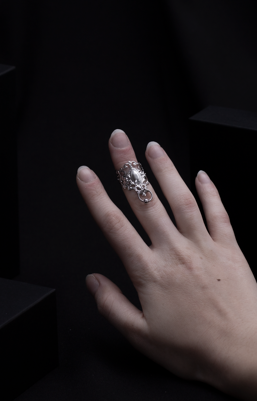 An alluring Myril Jewels midi ring with neo-gothic charm, featuring delicate filigree and a bold, tear-shaped centerpiece. Crafted for the dark fashion connoisseur, it's a quintessential accessory for a whimsigoth or witchcore ensemble, perfect for both daily gothic-chic statements and as an audacious festival jewel.