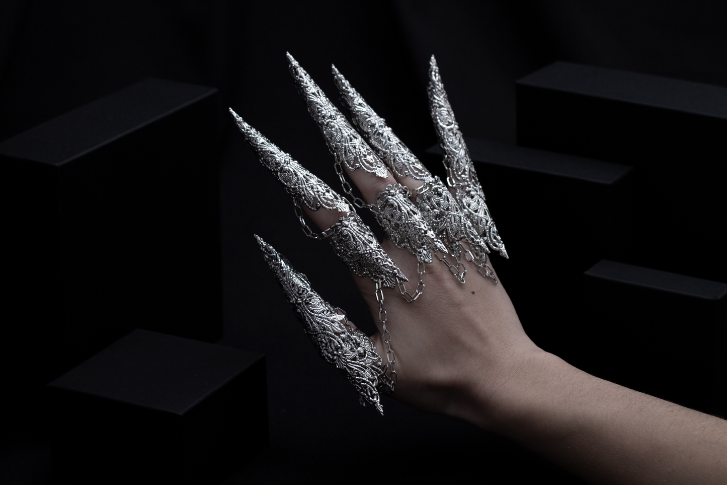 A hand is transformed into a fantastical vision with Myril Jewels' full dragon-like claw rings set, a bold example of neo-gothic artistry. This eye-catching design is a blend of Halloween elegance and avant-garde fashion, ideal for the gothic enthusiast looking to make a statement at any event