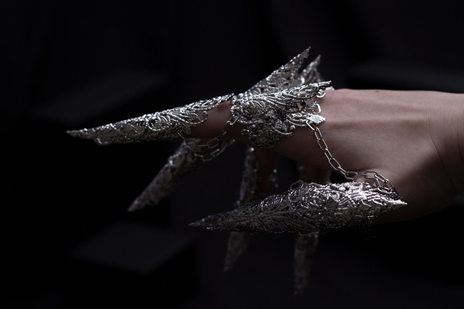 A hand is transformed into a fantastical vision with Myril Jewels' full dragon-like claw rings set, a bold example of neo-gothic artistry. This eye-catching design is a blend of Halloween elegance and avant-garde fashion, ideal for the gothic enthusiast looking to make a statement at any event