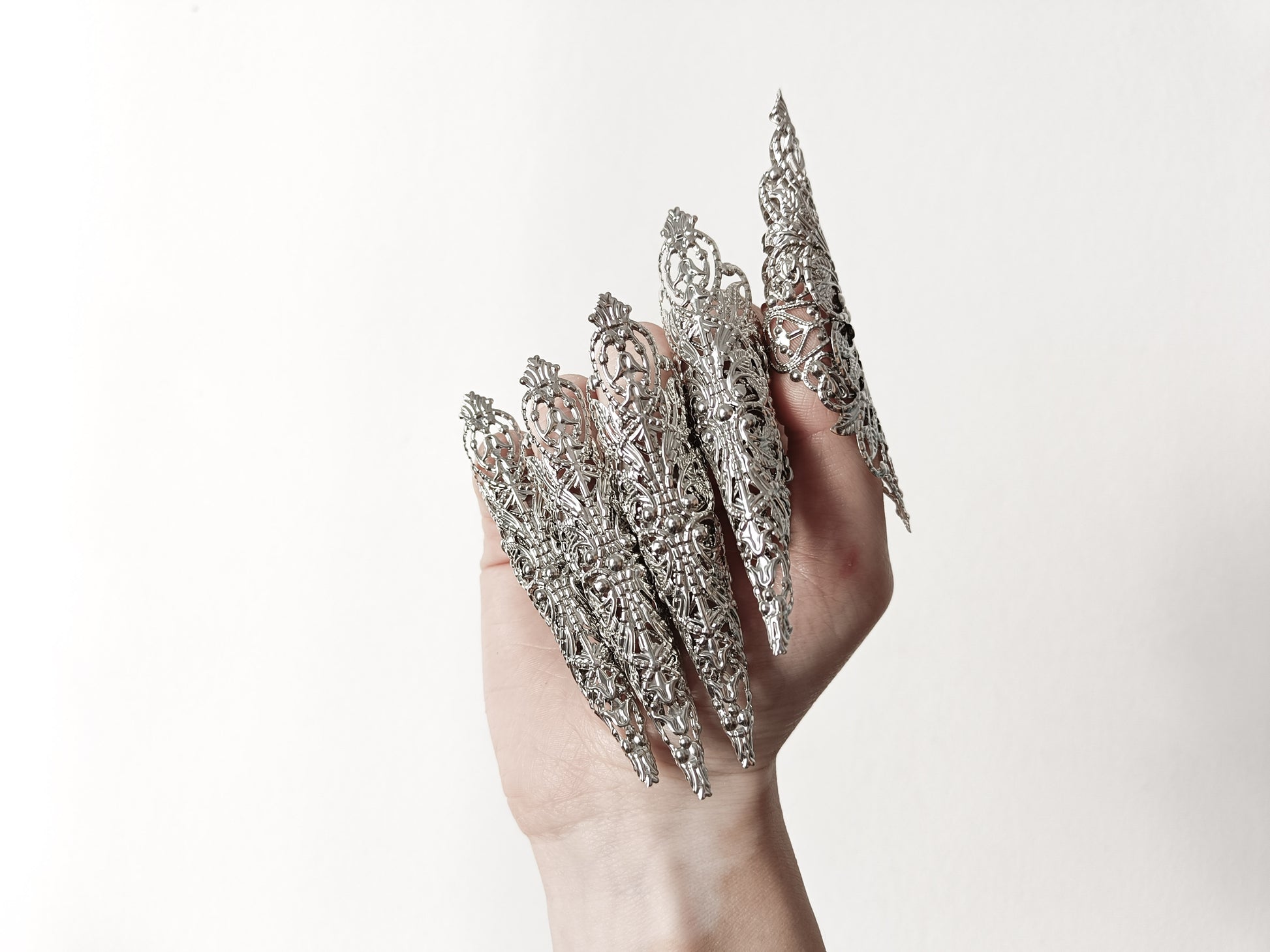 A hand adorned with a full set of Myril Jewels' extra long nail claw rings, showcasing a stunning neo-gothic design. These claws are a must-have for Halloween, adding a dark and bold edge to gothic-chic and witchcore styles, and are perfect for everyday wear or as a statement piece at a rave party or festival.