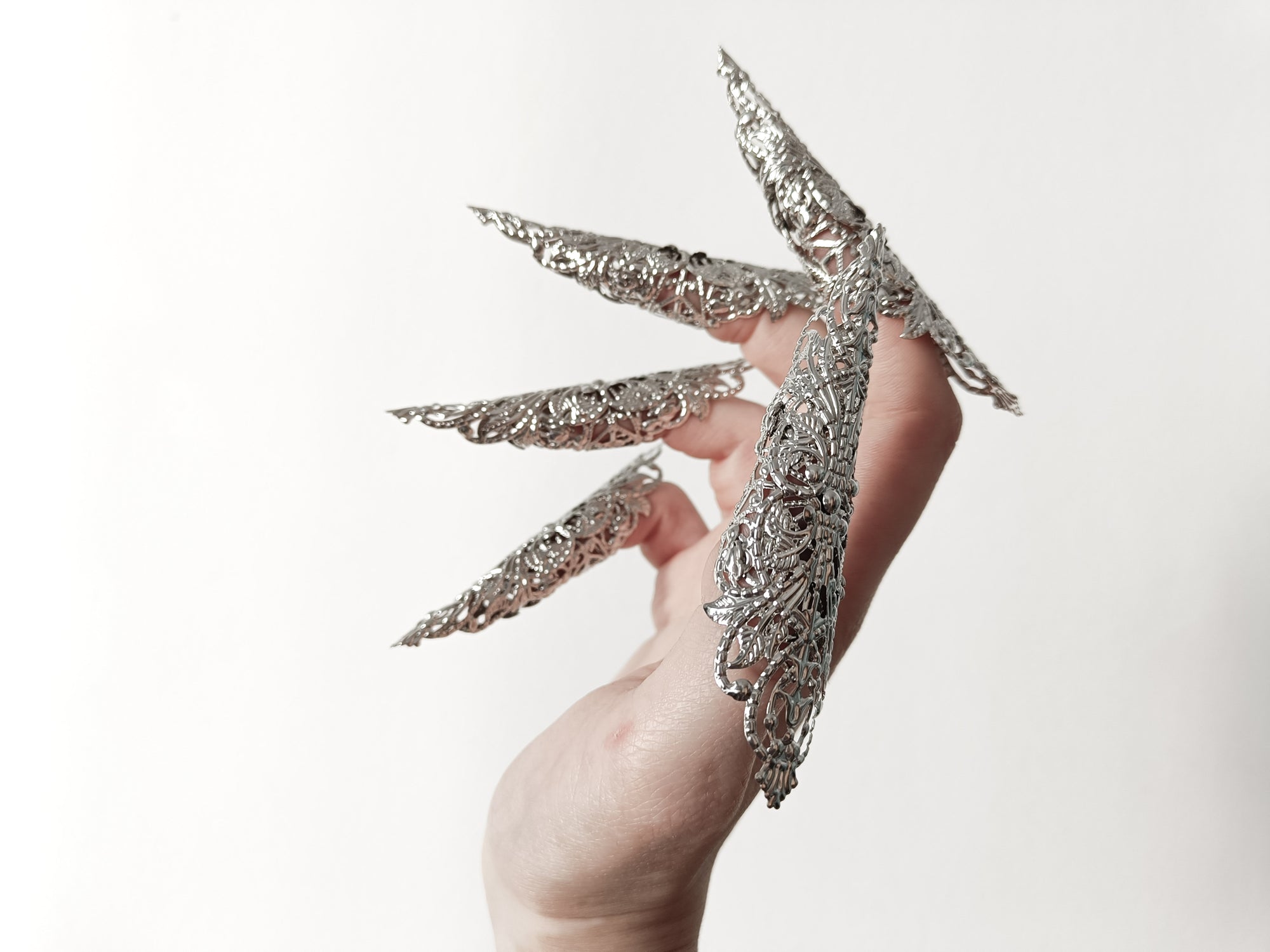 A hand adorned with a full set of Myril Jewels' extra long nail claw rings, showcasing a stunning neo-gothic design. These claws are a must-have for Halloween, adding a dark and bold edge to gothic-chic and witchcore styles, and are perfect for everyday wear or as a statement piece at a rave party or festival.