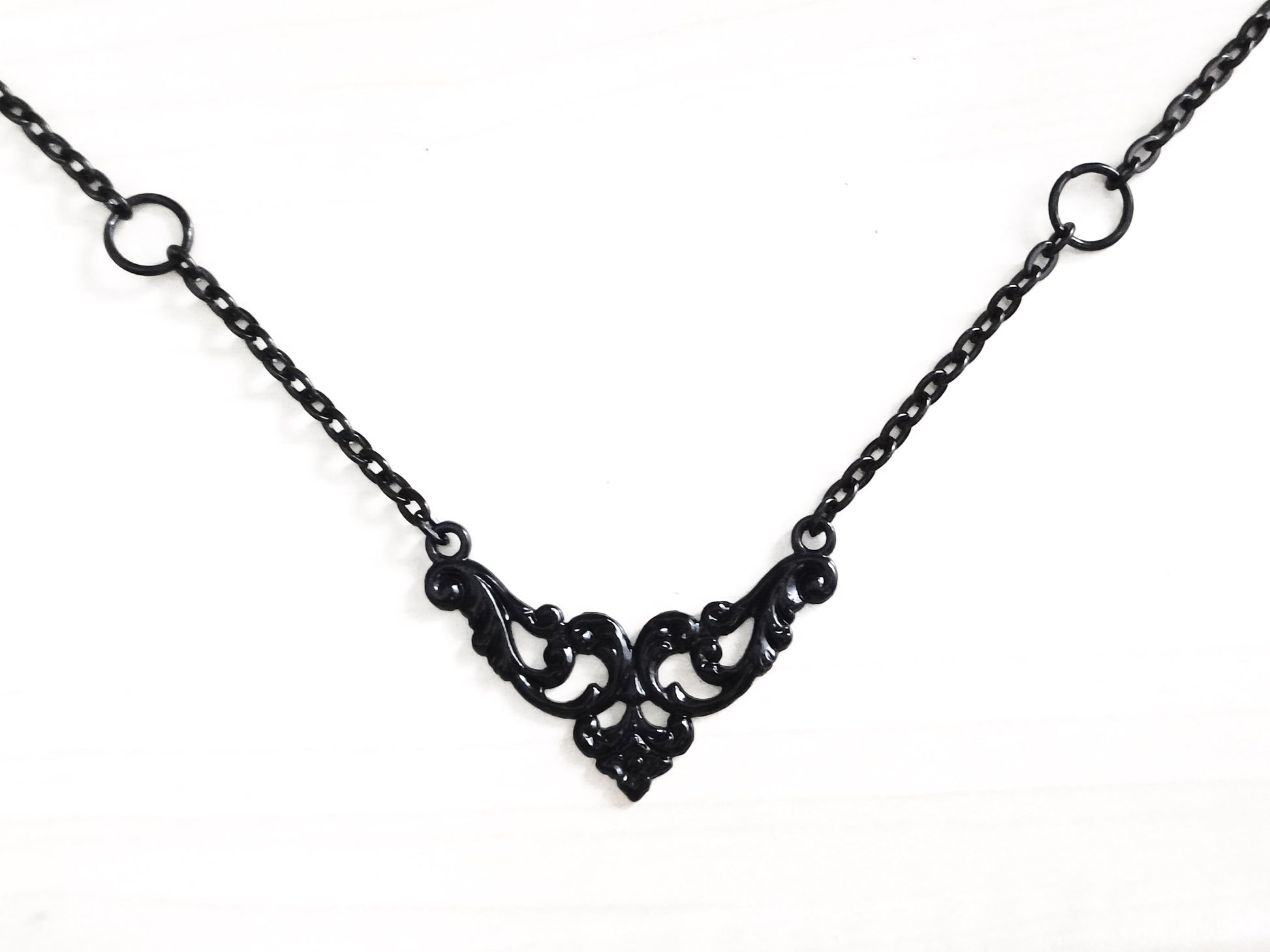 A Myril Jewels gothic necklace displayed on a mannequin, featuring delicate black filigree work that forms an elegant centerpiece. The black necklace combines timeless gothic motifs with modern elegance, making it a versatile piece for Halloween events, punk fashion, and everyday wear. It reflects the dark-avantgarde style that Myril Jewels is known for, appealing to those who favor gothic-chic, whimsigoth, and witchcore aesthetics