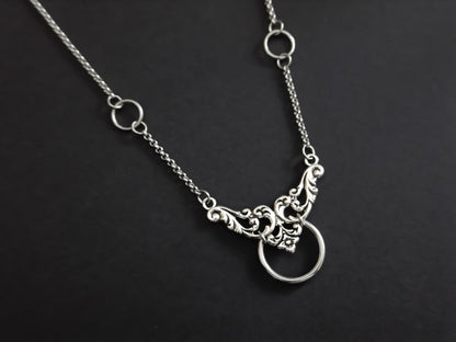 An elegant Myril Jewels chain choker with a floral motif and central O-ring, merging neo-goth style with dark-avantgarde sophistication, suitable for various occasions from everyday wear to special events
